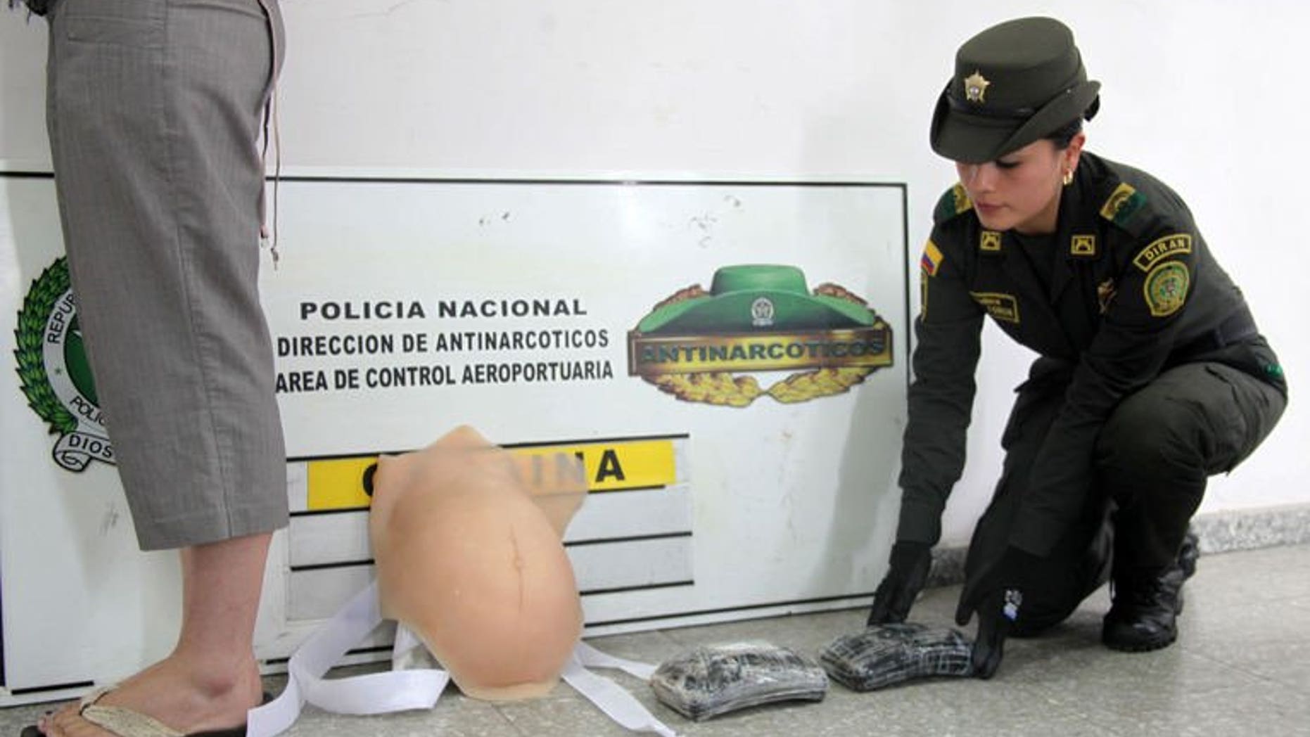 A picture released by Colombia's Police on September 11, 2013 shows Canadian national Leah Ritchie (L) after being detained at Bogota airport while pretending to be pregnant and attempting to board a flight carrying 2kg of cocaine hidden under a latex belly.