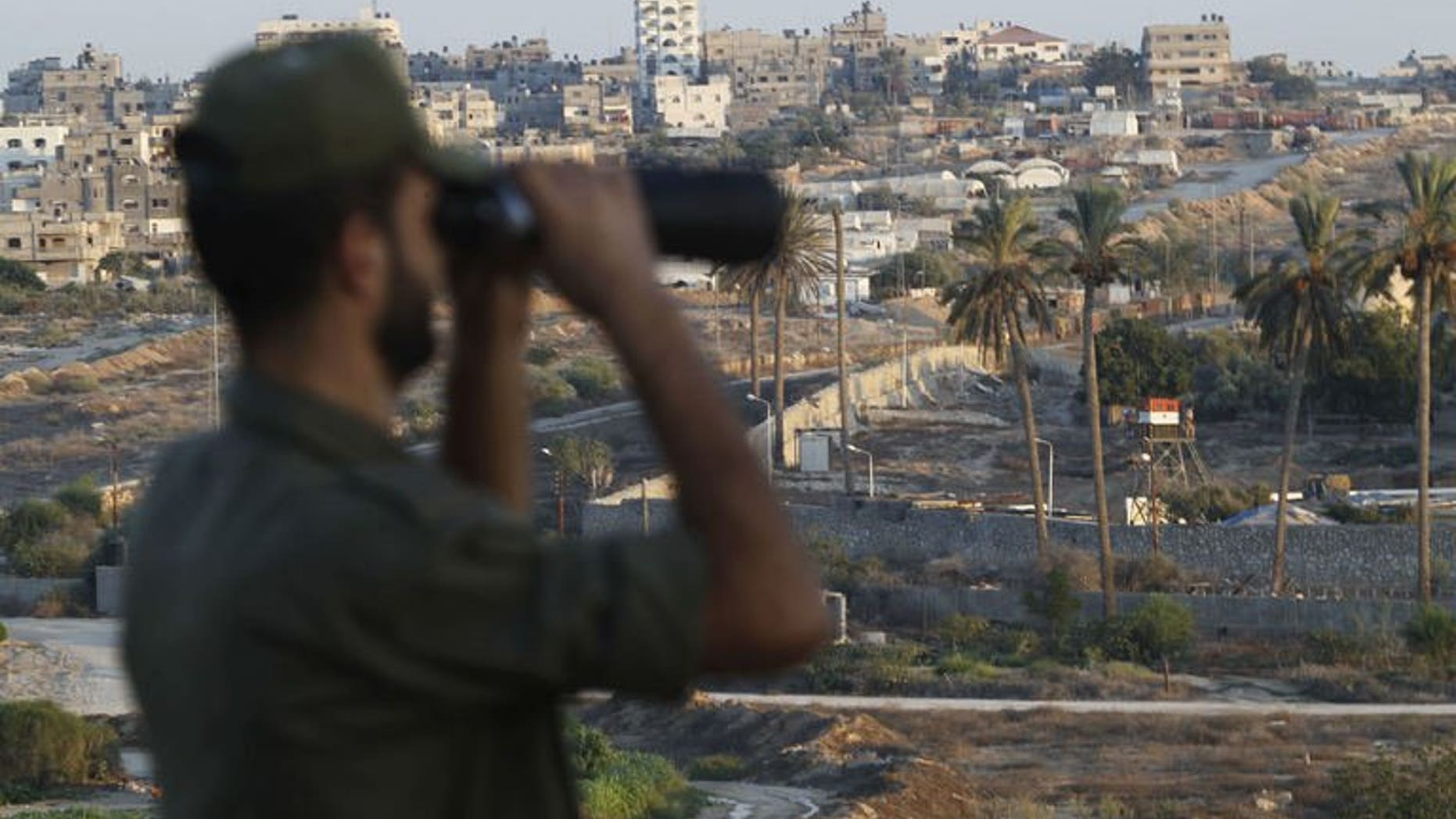 A Palestinian Hamas security guard looks through a pair of binoculars while on duty at the border between Egypt and Gaza Strip, in Rafah town southern Gaza Strip, on September 11, 2013.