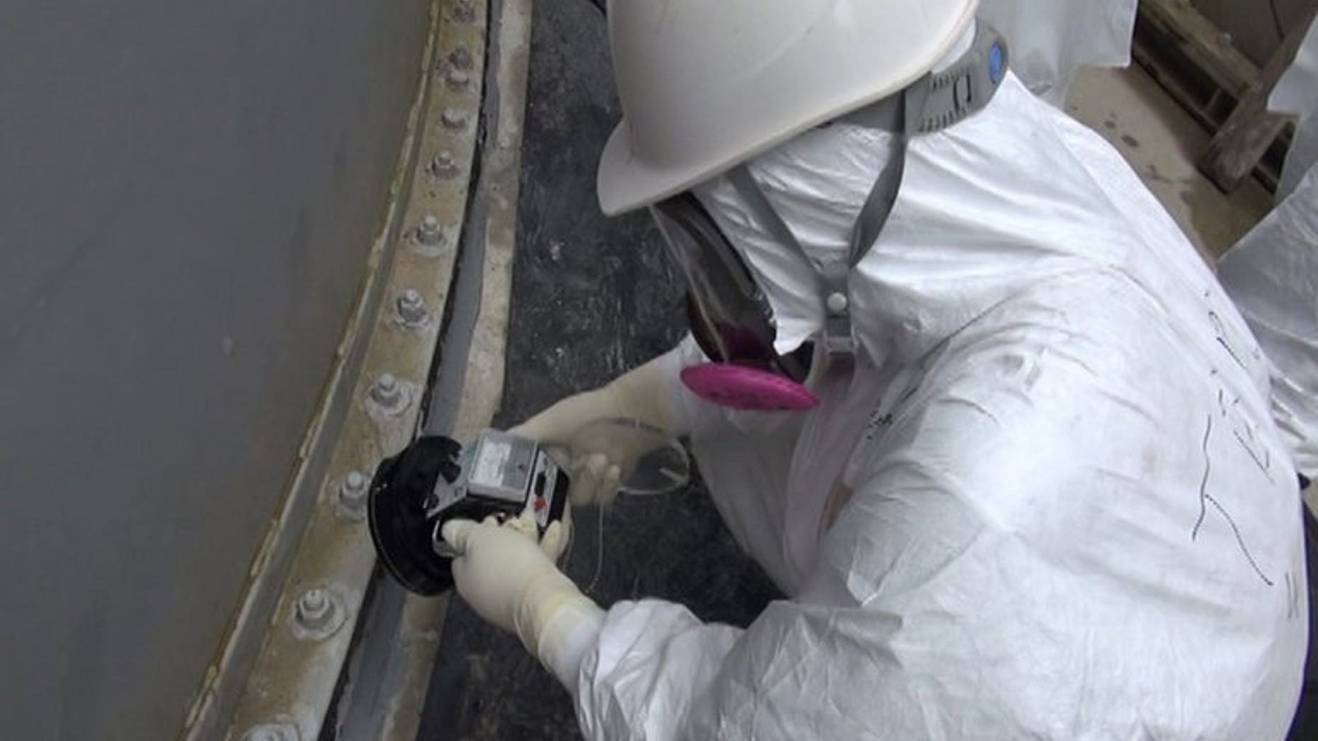 Image taken by TEPCO on September 4, 2013 shows a worker checking radiation levels at a water tank at the Fukushima nuclear power plant. Vapour has begun rising again from a reactor at the plant, more than two-and-a-half years after its core melted down, TEPCO said Friday.