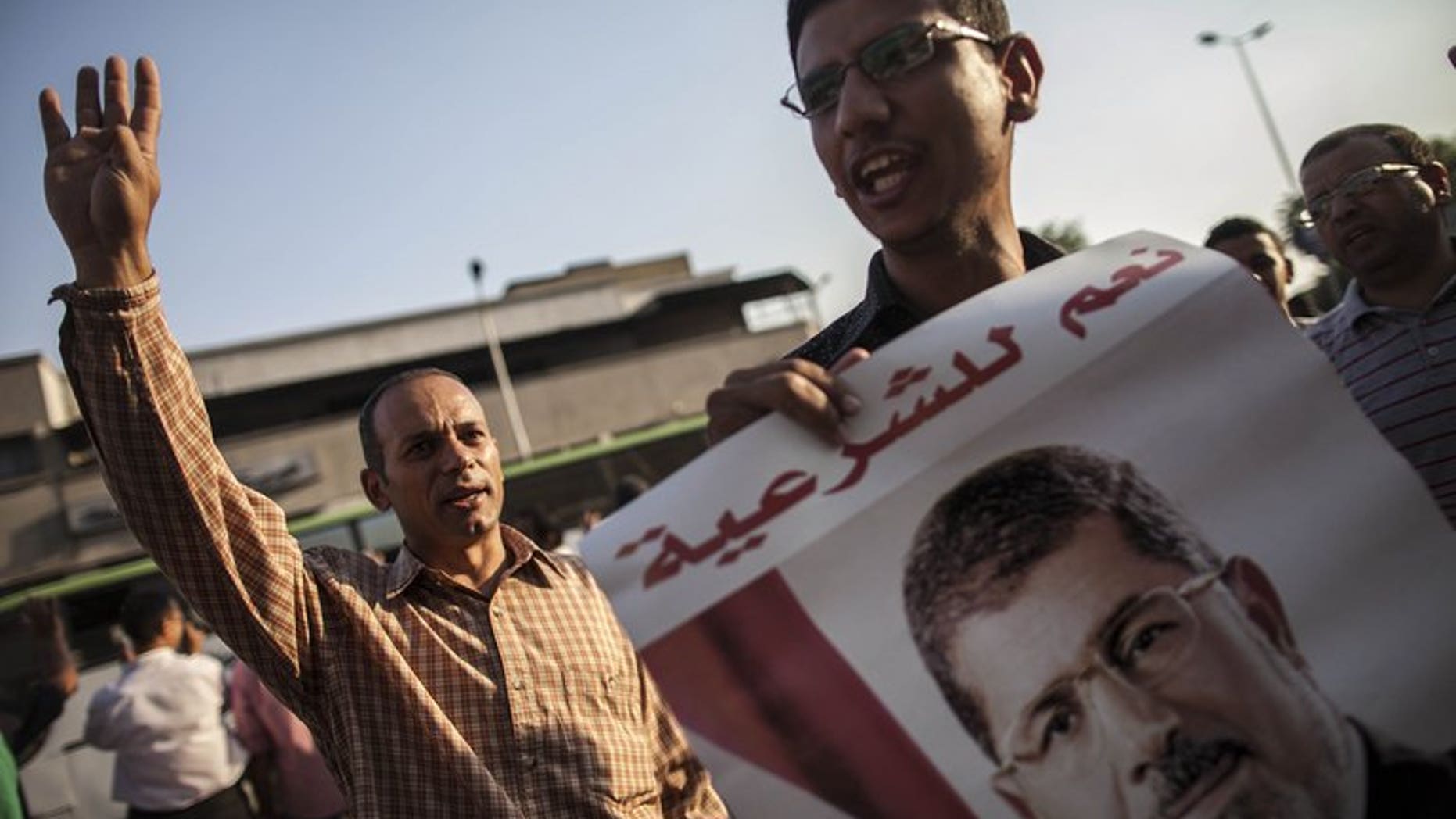 Muslim Brotherhood members and supporters of ousted president Mohammed Morsi show his portrait during a demonstration against the army-installed government on September 10, 2013 in Cairo. Morsi supporters rallied in Cairo after Friday prayers chanting angry slogans against the military, with clashes reported elsewhere in Egypt.