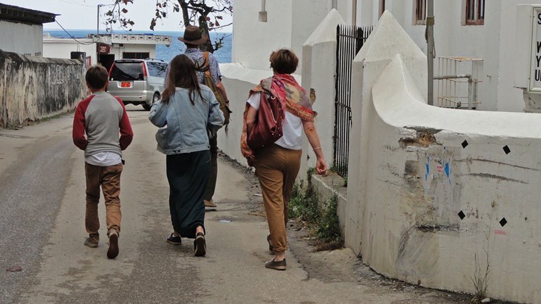 Tourists walk in Stone Town past the spot where two young British women suffered an acid attack on the Indian Ocean island of Zanzibar on August 9, 2013.
