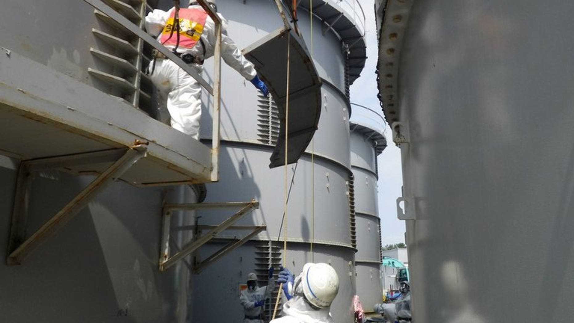 Workers prepare to take apart a contamination water tank at the Fukushima Dai-ichi nuclear plant in Okuma, Japan, in a photo by Tokyo Electric Power Co (TEPCO) on September 13, 2013. Japan's nuclear authority plans to conduct radiation contamination surveys at 600,000 points on the seabed off the crippled Fukushima nuclear plant, up from 200 places so far, a report said Saturday.
