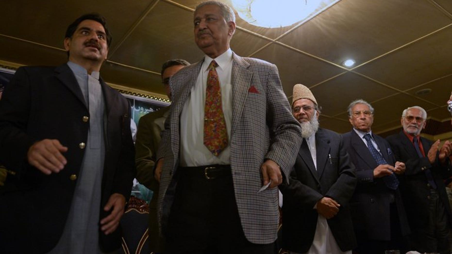 Former Pakistani nuclear scientist and chairman of Tehreek-e-Tahafuz Pakistan party, Abdul Qadeer Khan (2L), stands to give a speech during a public meeting in Islamabad on February 26, 2013.