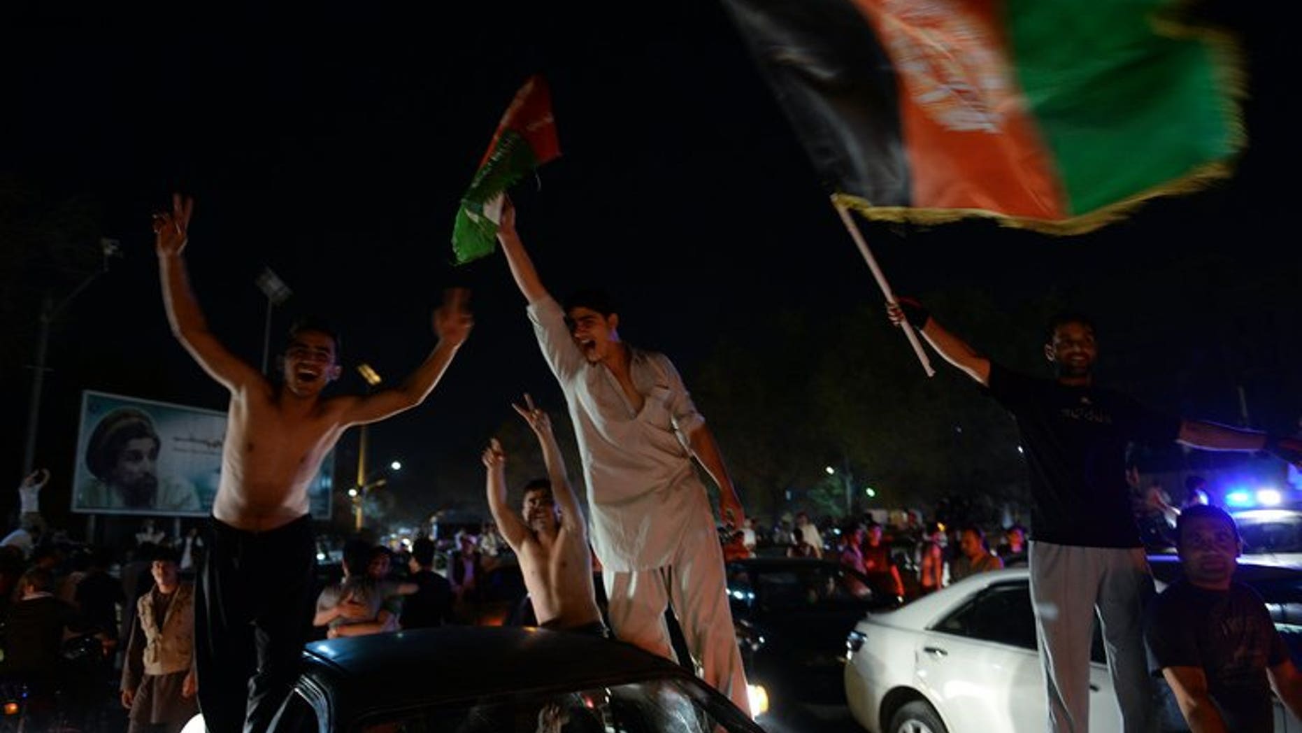 Afghan football fans celebrate winning the SAFF Championship 2013 trophy after their team defeatied India during the final match, in the streets of Kabul on September 11, 2013.