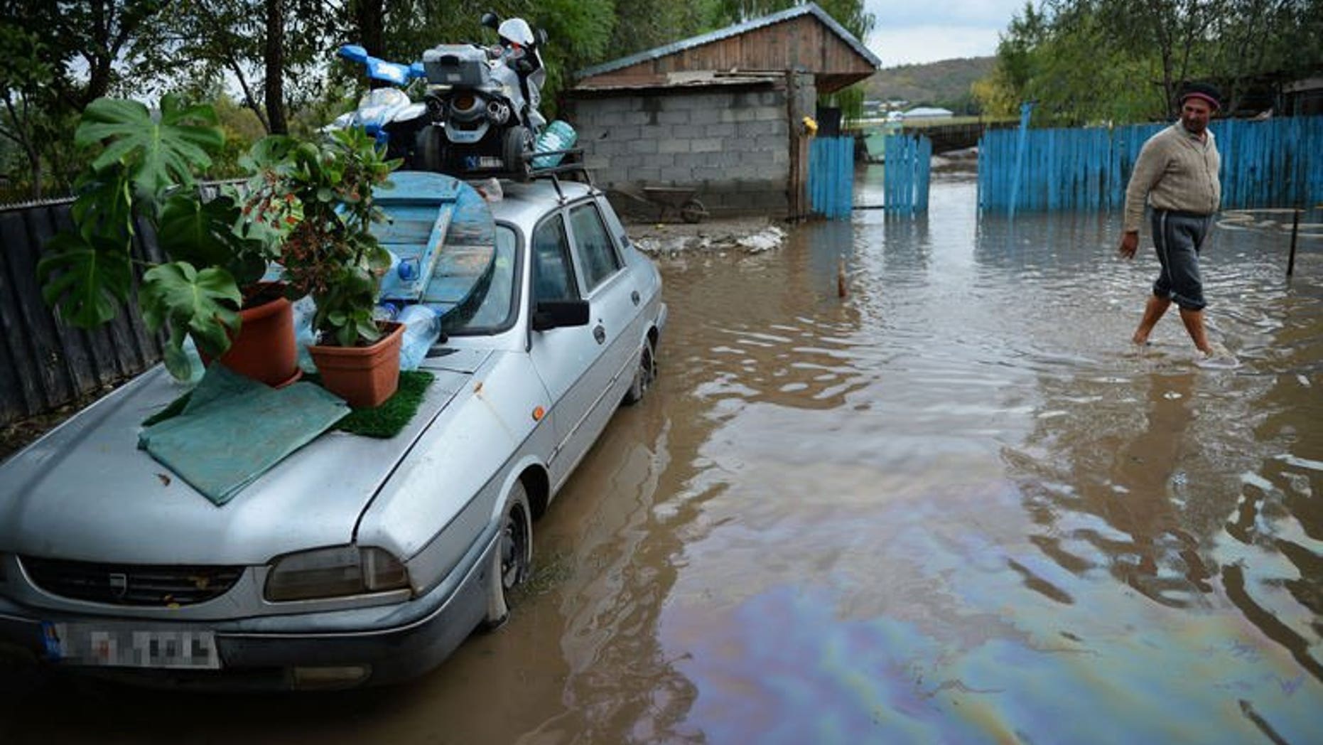 A man walks through flooded courtyard in Slobozia Conachi, eastern Romania on September 14, 2013. Flash floods have killed nine people and forced thousands to flee their homes in eastern Romania in the last four days, the authorities said Sunday.