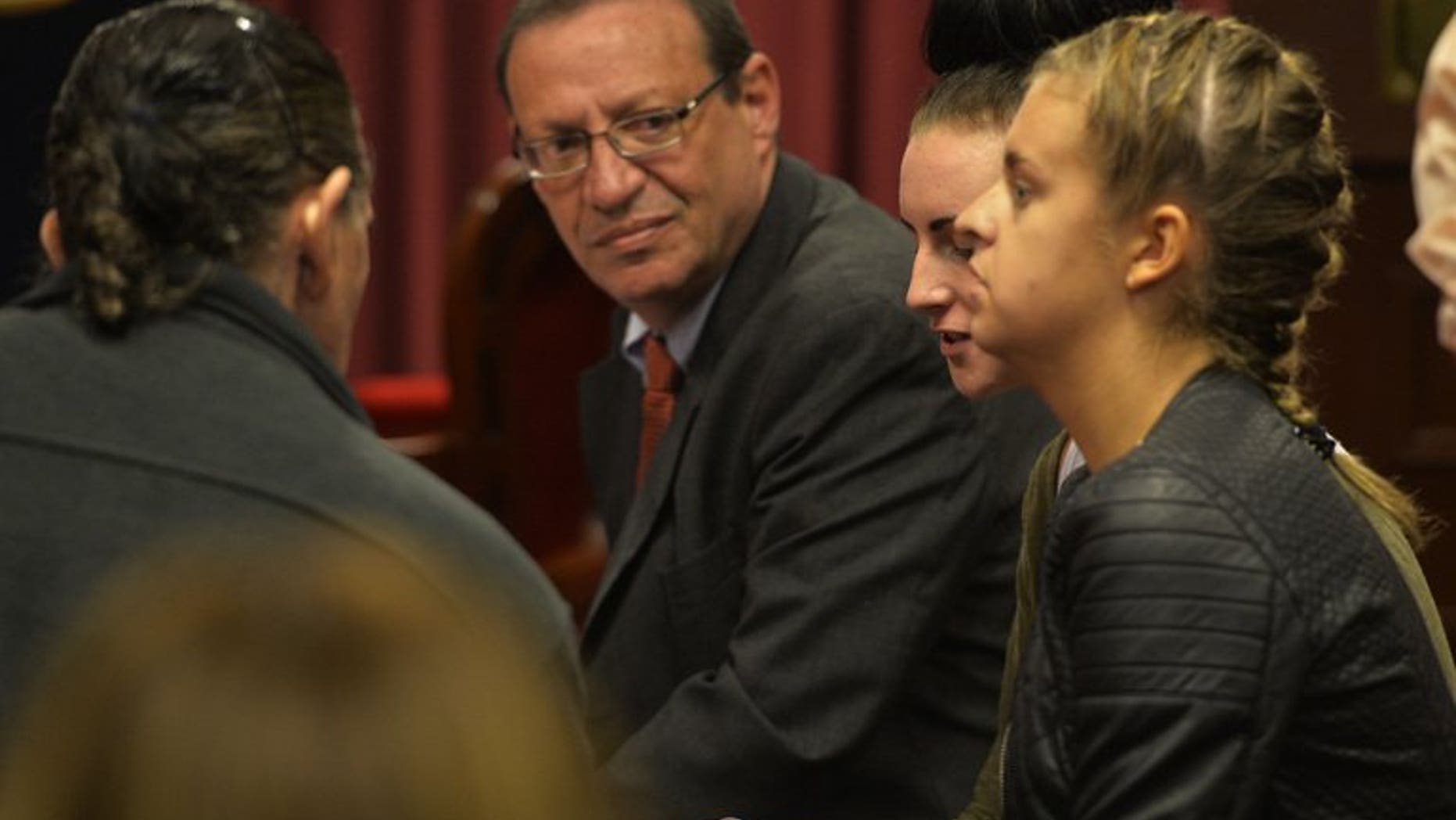 Irishwoman Michaella McCollum, 20, (C) and Briton Melissa Reid, 20, arrested at Lima's airport for carrying cocaine in their luggage, sit in a courtroom with their Peruvian lawyer Meyer Fishman (L), during a court hearing in Callao on August 21, 2013.