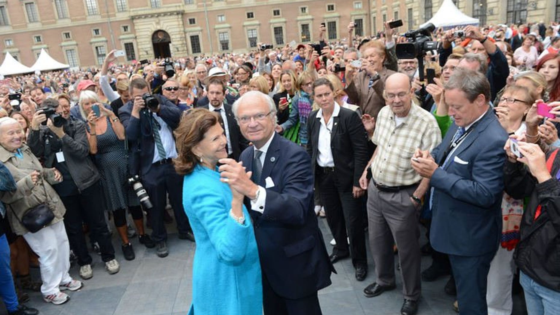 Queen Silvia and King Carl Gustaf of Sweden lead a dance in the palace courtyard in Stockholm on September 15, 2013.