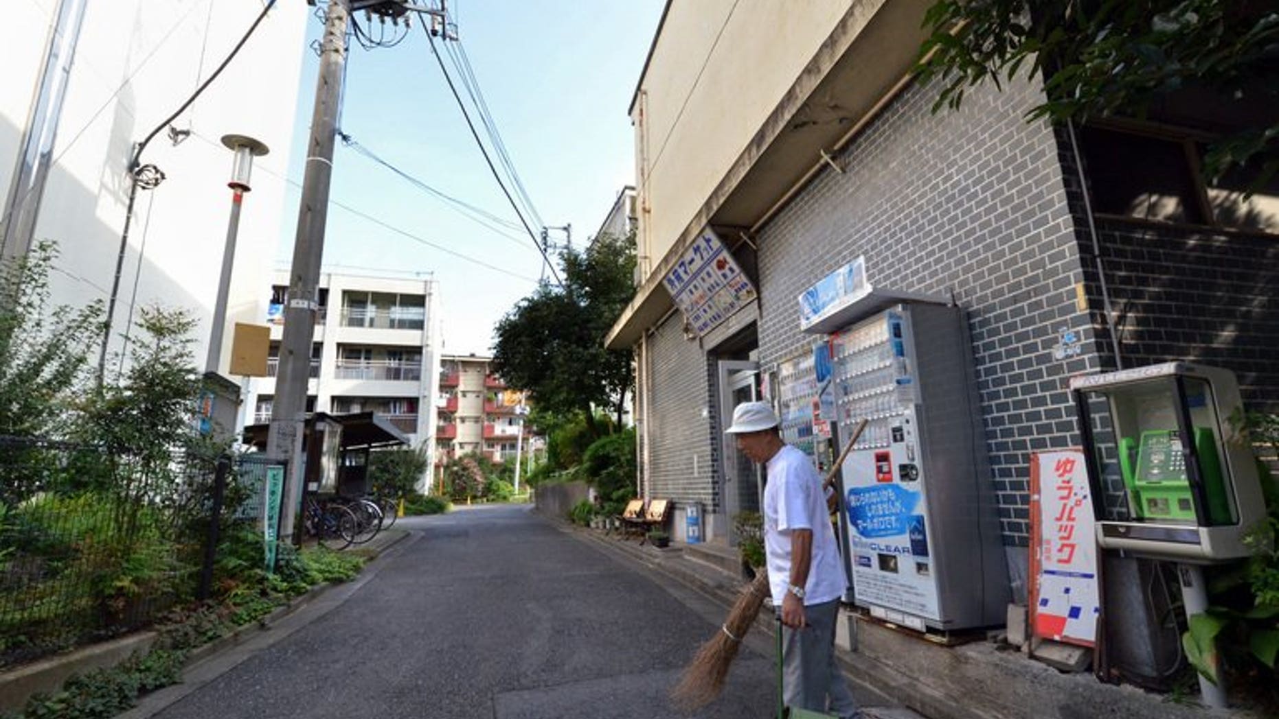 In this picture taken on September 14, 2013, 79-year-old resident Kohei Jinno sweeps and cleans a road before his apartment complex near the rebuilt national stadium in Tokyo.