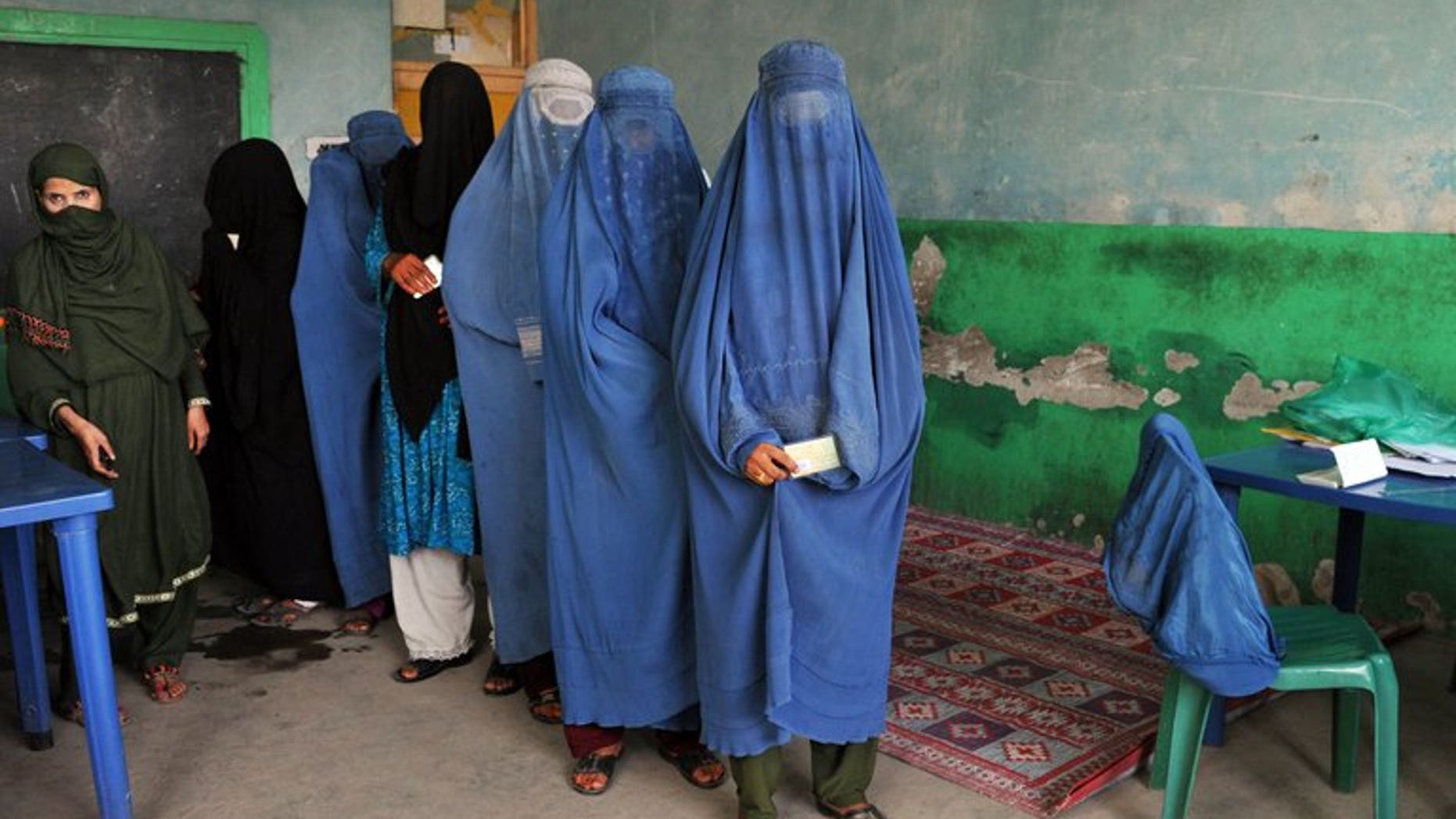 Afghan women wait in line to receive voter identification cards at a poll registration centre in Jalalabad on September 7, 2013.