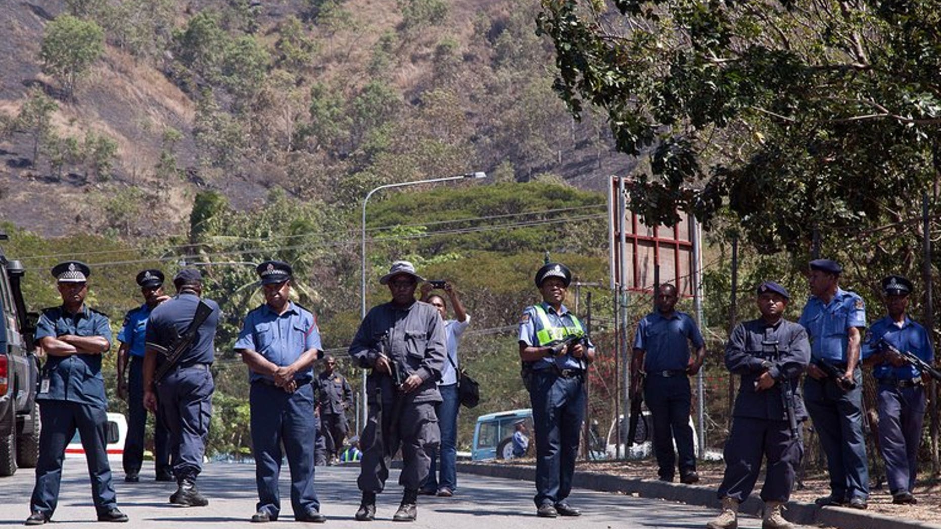 PNG police look on at a student march in Port Moresby on August 2, 2013. A third man died of his injuries following an ambush on foreign trekkers in Morobe province.
