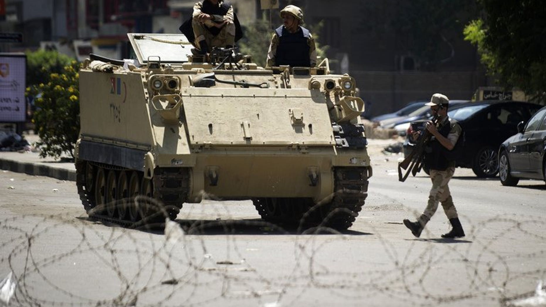 Egyptian army soldiers sit on top of an armoured personnel carrier in Cairo on August 23, 2013. Troops stormed a central Egyptian town held for over a month by hardline supporters of ousted Islamist president Mohamed Morsi who had launched a campaign against Christian residents.