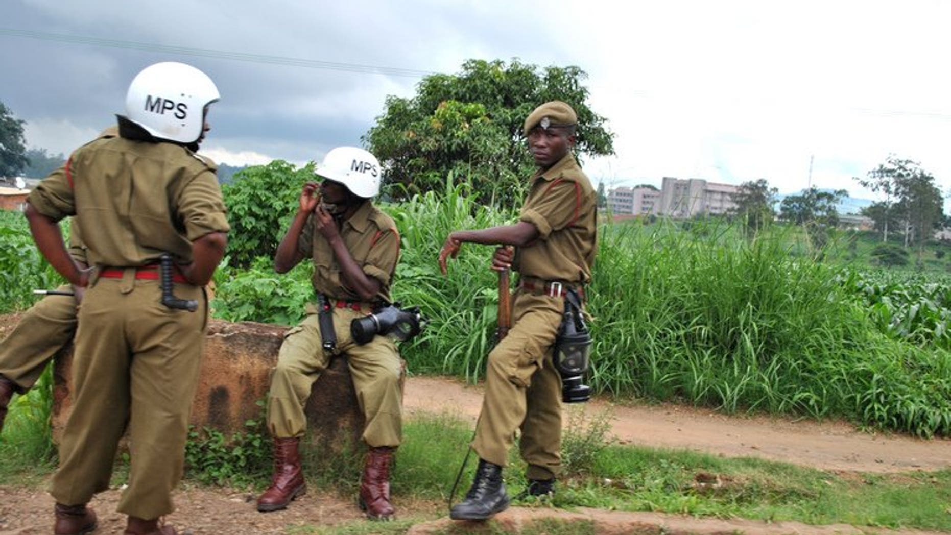 Police officers rest near a market in Blantyre on January 17, 2013. A court in Malawi has jailed nine senior police officers to 14 years each for fraud.
