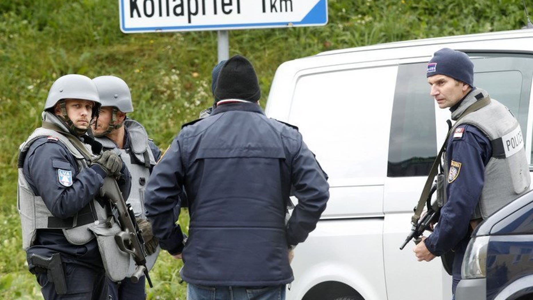 Austrian armed police block a road near Grosspriel, on September 17, 2013. Austrian prosecutors have said a poacher who killed three policemen and a paramedic most likely died after shooting himself in the head.