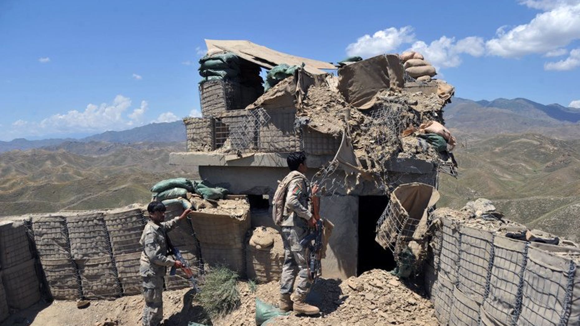 Afghan border policemen inspect a bunker destroyed during clashes between Afghan border police and Pakistani troops in Goshta district of Nangarhar province on May 8, 2013. Pakistan accused Afghan forces of killing five Pakistanis on Wednesday in cross-border "indiscriminate firing" in its southwestern Baluchistan province.