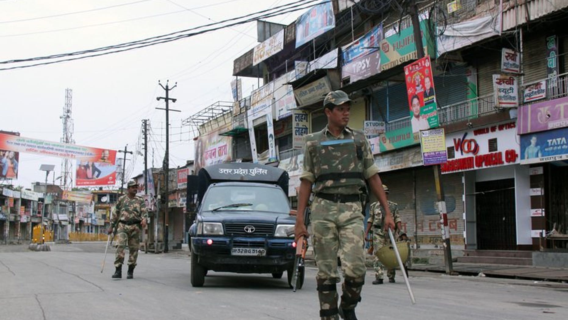 Indian soldiers patrol alongside a state police vehicle on a deserted street following communal riots between Muslims and Hindus in Muzaffarnagar, India's Uttar Pradesh state, on September 8, 2013.