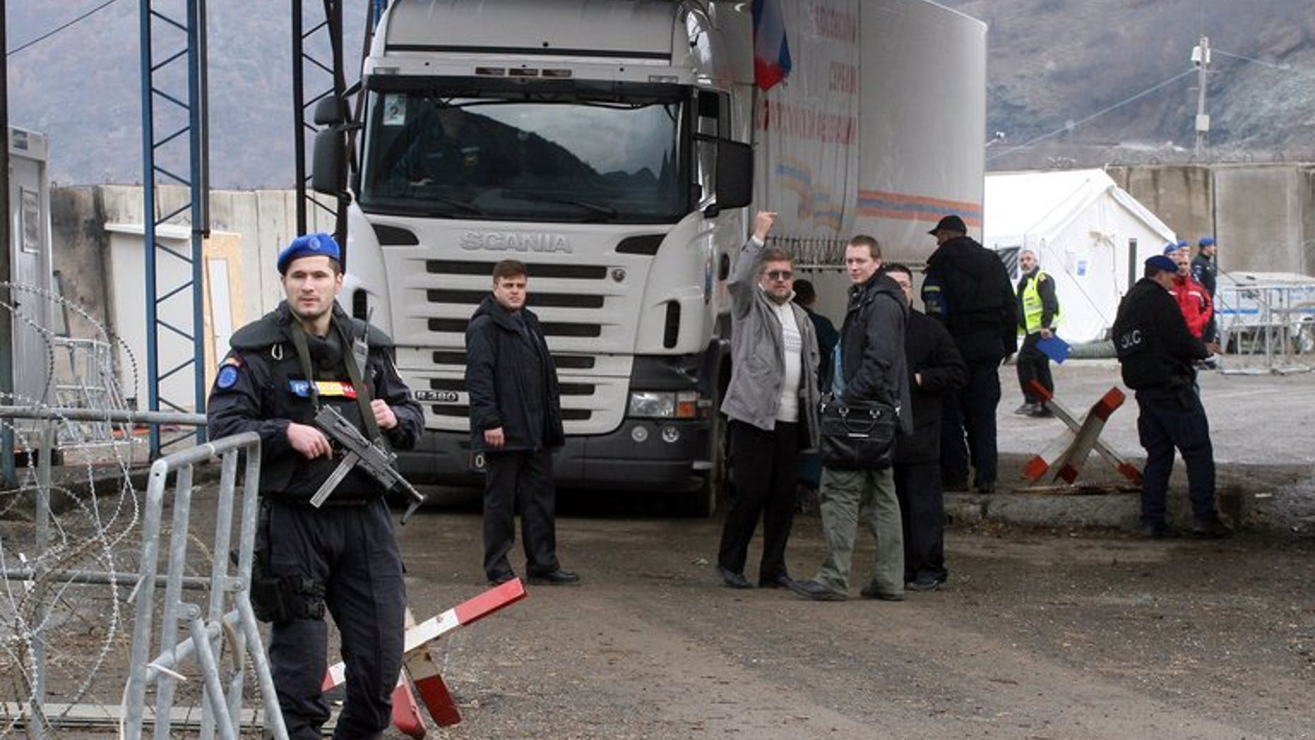 A Romanian officer of the European Union's police force in Kosovo stands guard in front of a truck carring Russian aid at the Jarinje border crossing between Serbia and northern Kosovo on December 13, 2011. Gunmen shot dead a member of the European Union's police force in Kosovo's flashpoint northern region Thursday, in the first deadly attack on the mission since its creation five years ago.