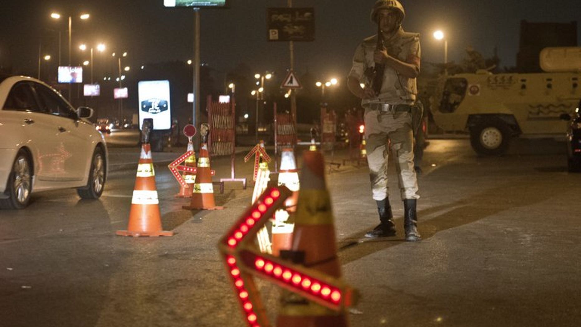 Troops keep watch at a checkpoint during the curfew hours in Cairo late on August 19. Egypt is to shorten a night-time curfew imposed on Cairo and 13 provinces starting Saturday, the cabinet said on Thursday.