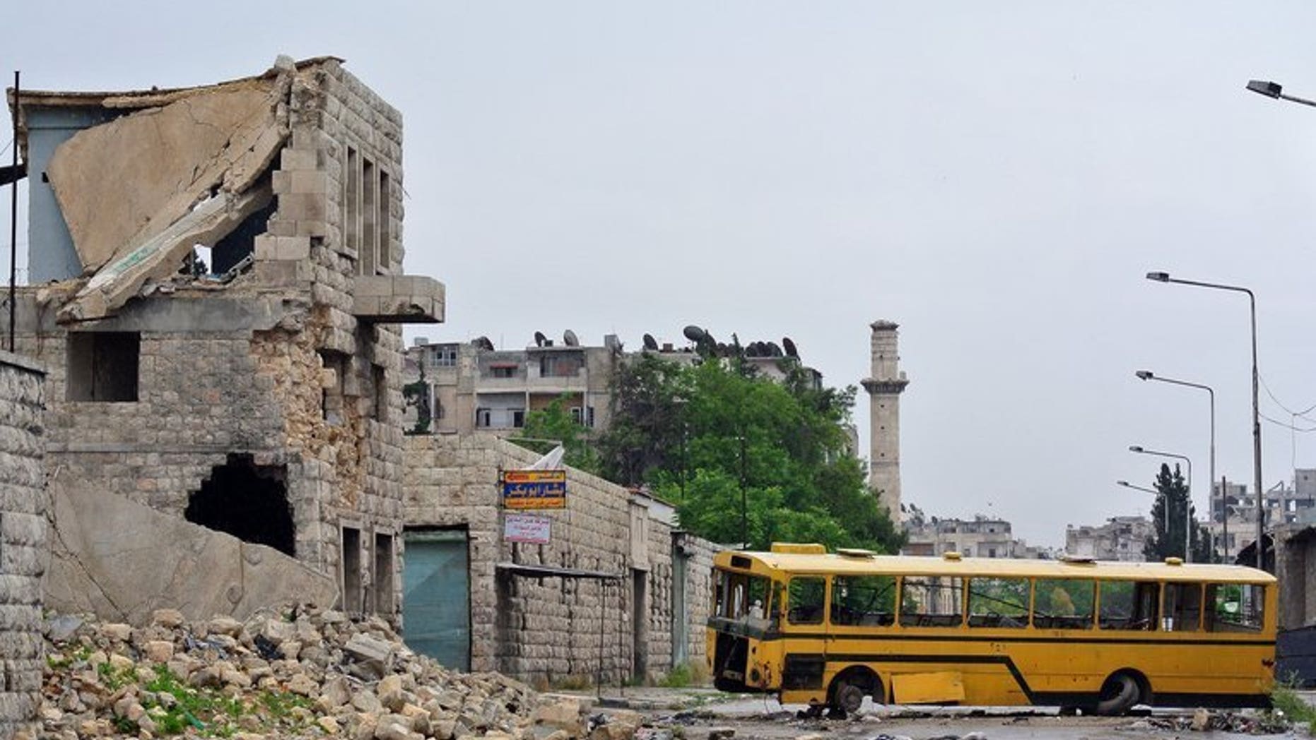 A bus is used as a barricade in Aleppo, on May 13. Roadside bombs targeting a convoy of minibuses in Syria's Homs province killed nine people on Thursday, the Syrian Observatory for Human Rights said.