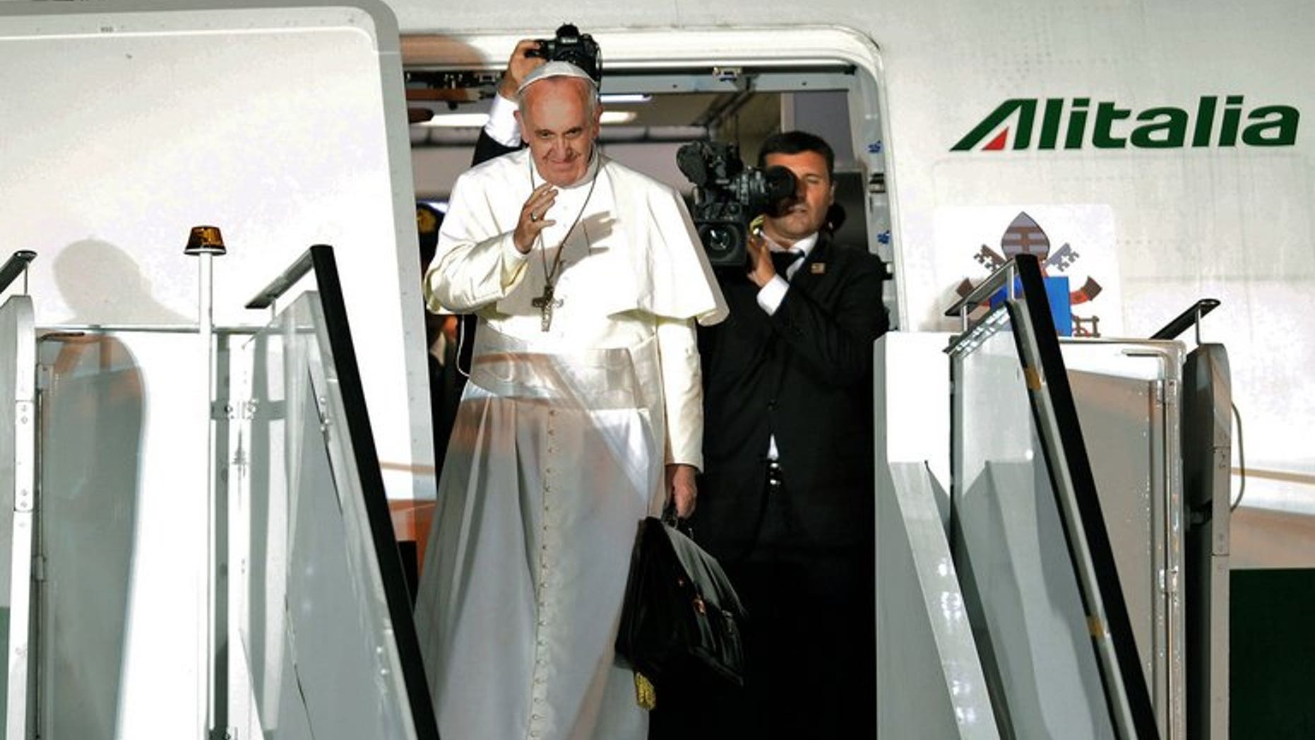 Pope Francis waves as he boards the plane after a week-long trip to Brazil, on July 28, 2013. Pope Francis on Thursday lashed out at what he called the scandal of "airport bishops", urging his peers to remain rooted in their dioceses and spend less time seeking the spotlight.