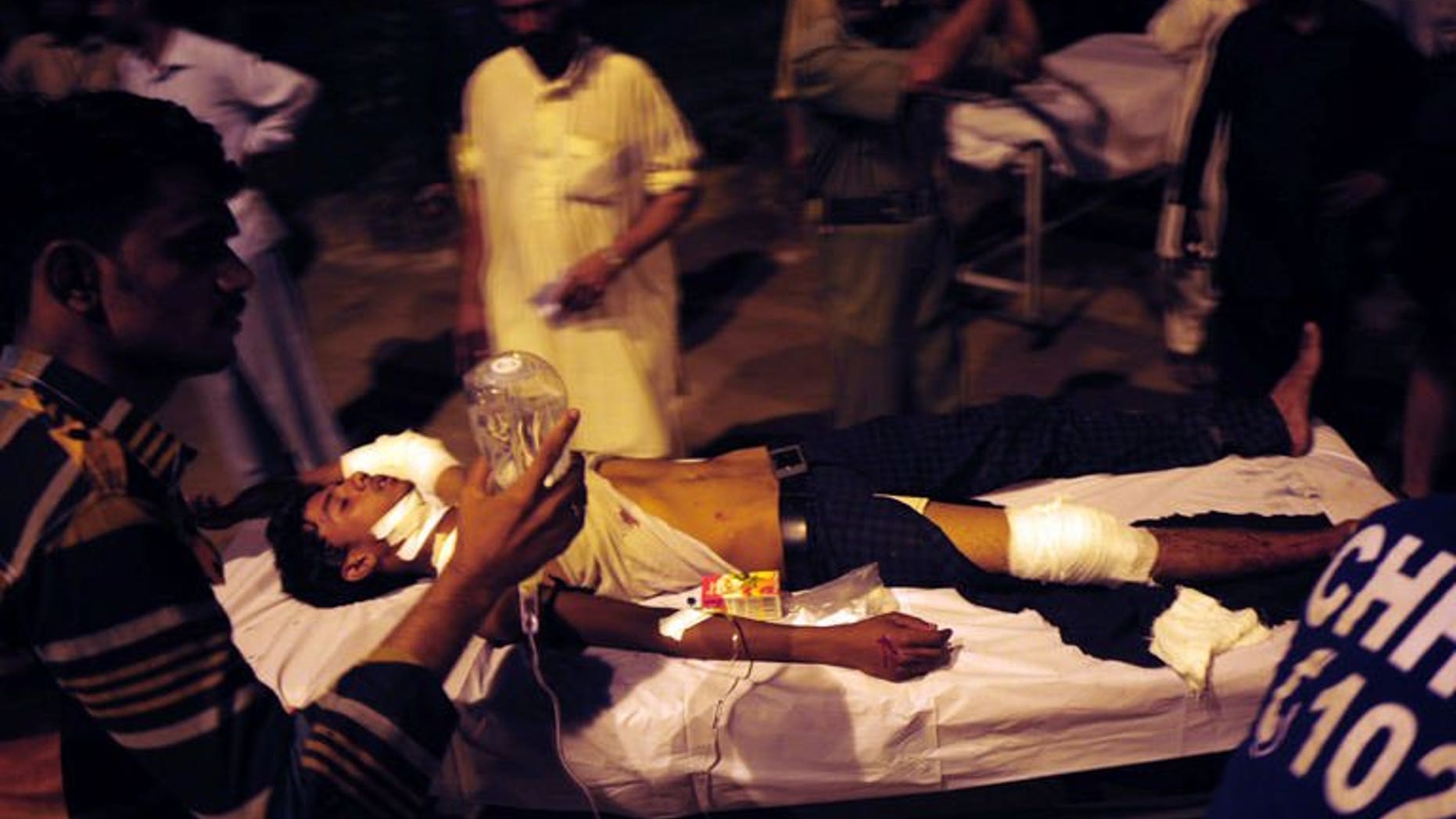 Pakistani men carry injured victims to a hospital after a grenade attack in Karachi on September 19, 2013.
