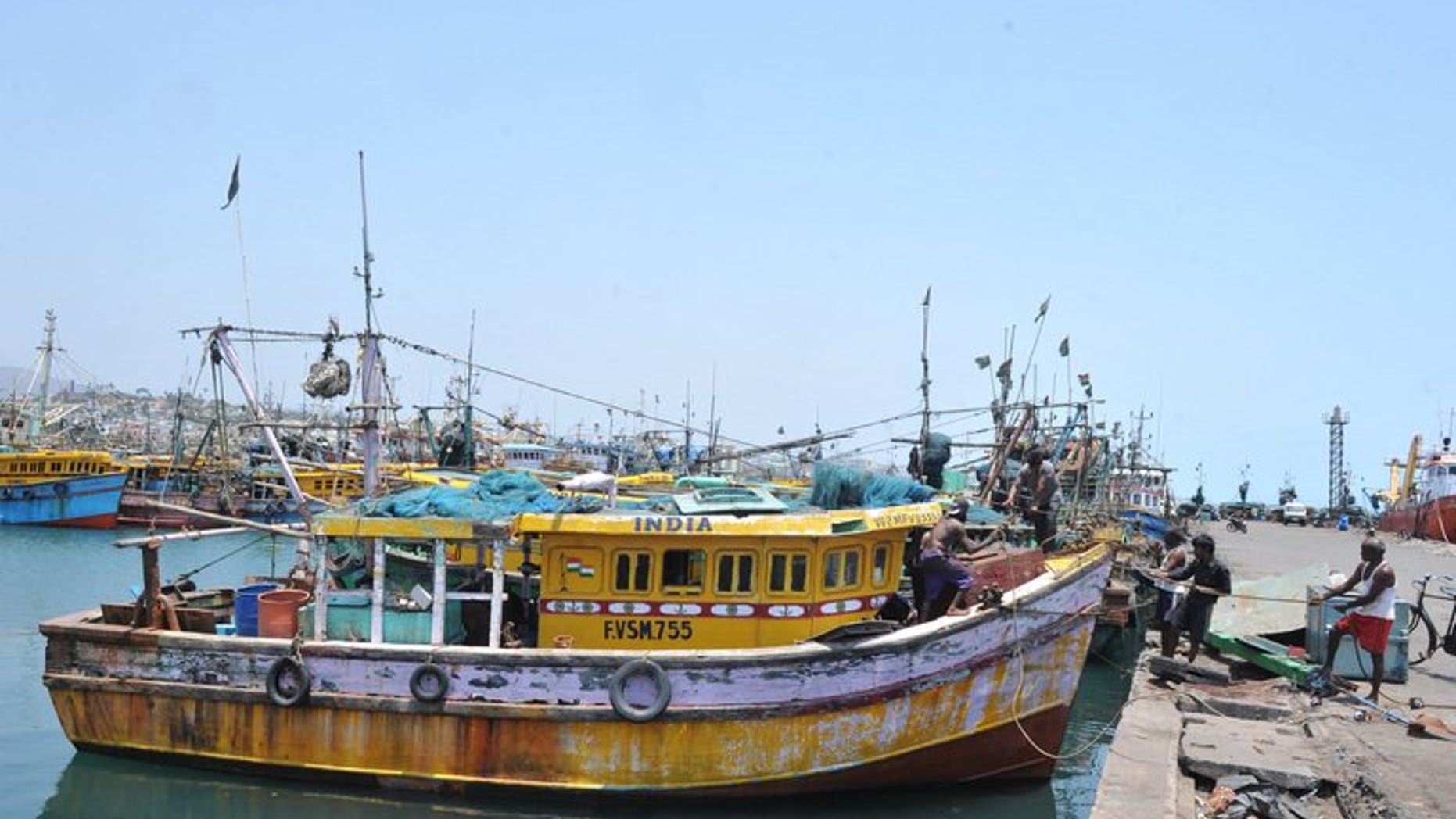Indian fishermen work on the dockside in Visakhapatnam on April 9, 2012.