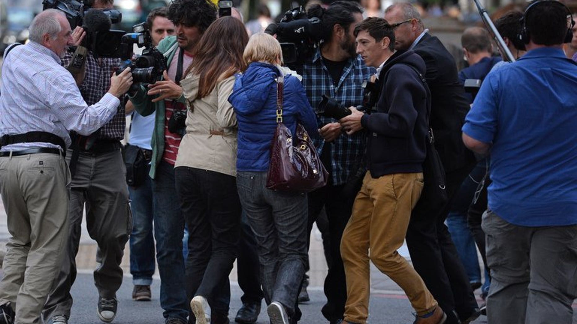 Anne (centre R) and Daniela Skinner (centre L), wife and daughter of alleged Mafia boss Domenico Rancadore, are pursued by the media, outside Westminster Magistrates court in London, on August 9, 2013.