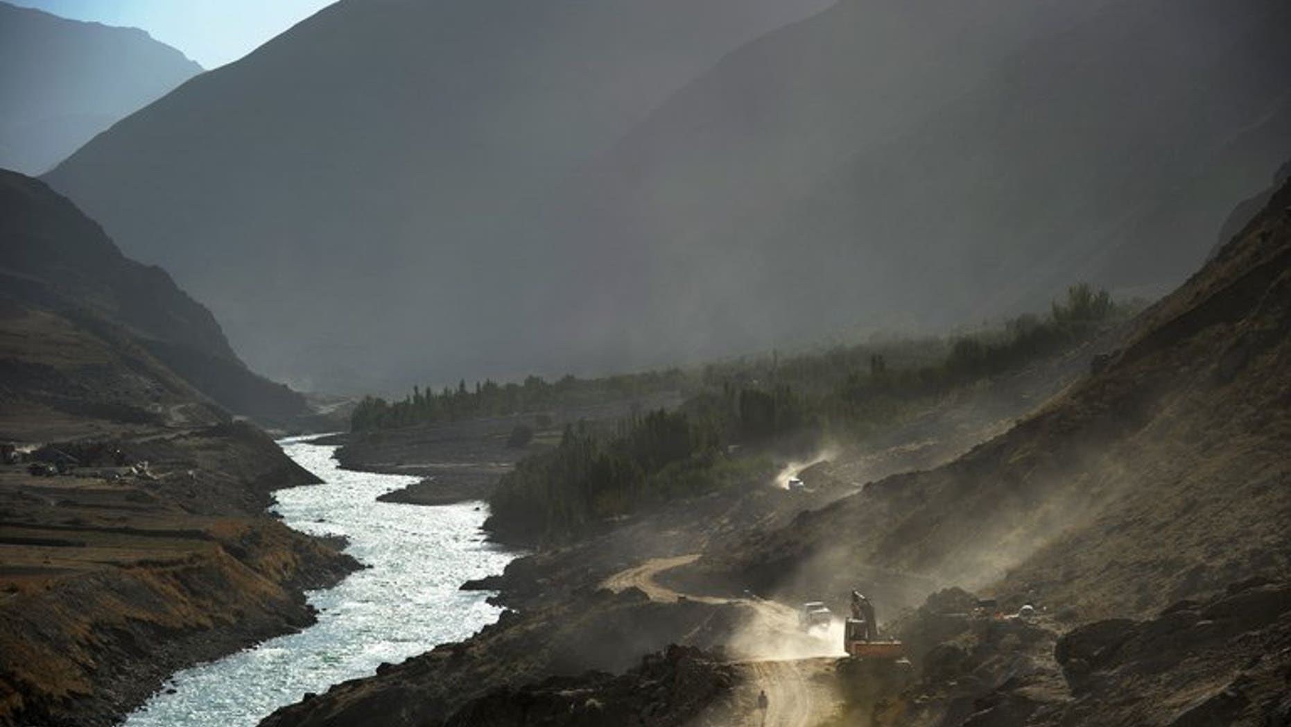 File photo taken on October 6, 2012 shows a man (bottom R) walking on the main road leading east from Faizabad, the capital of the province of Badakhshan, northeast Afghanistan.