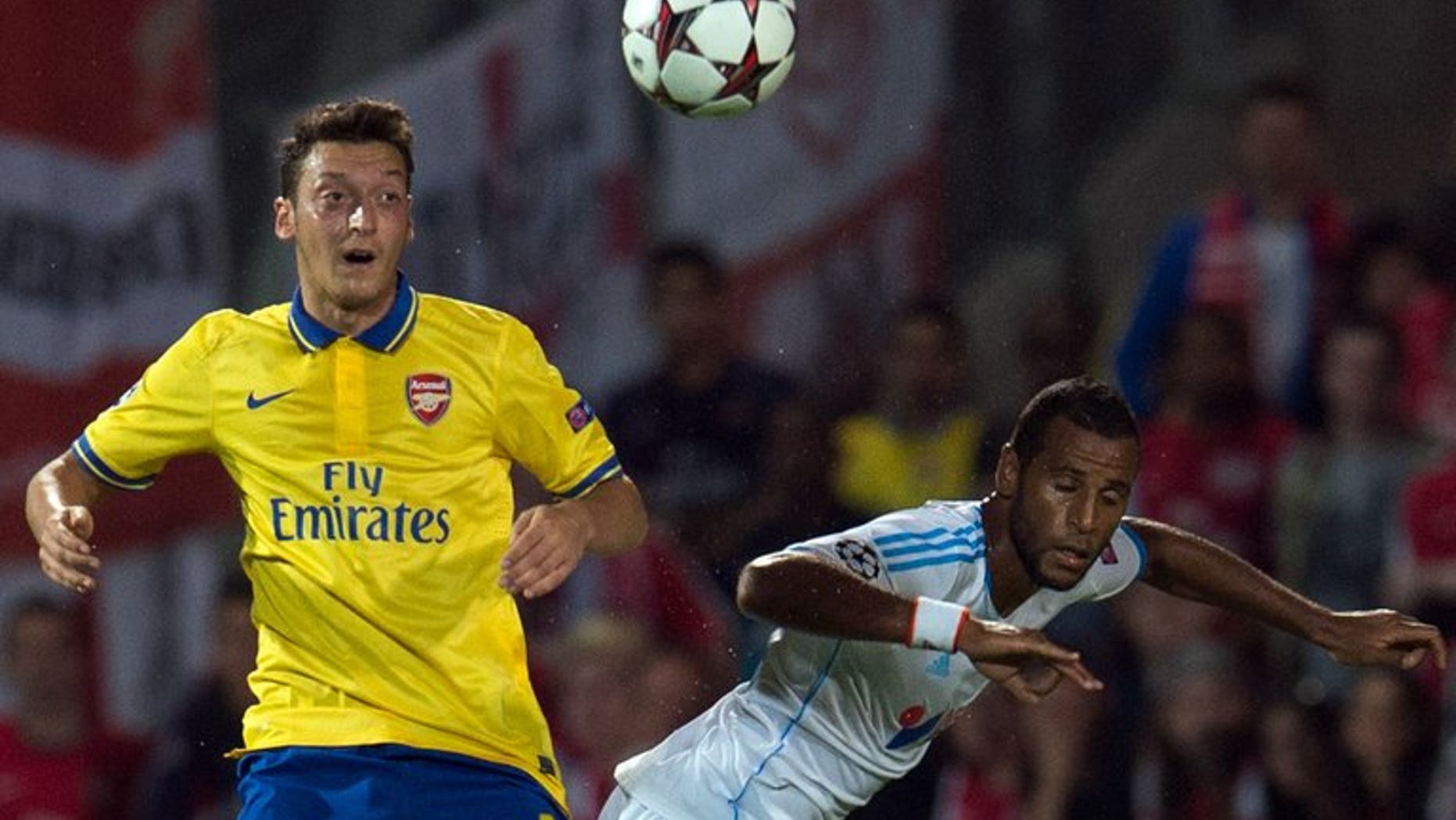 Mesut Ozil (left) clashes with Marseille's Jacques-Alaixys Romao at the Velodrome stadium on Wednesday. Arsenal manager Arsene Wenger has insisted club-record signing Mesut Ozil didn't leave Spanish giants Real Madrid because he wanted an easier life with the north London club.
