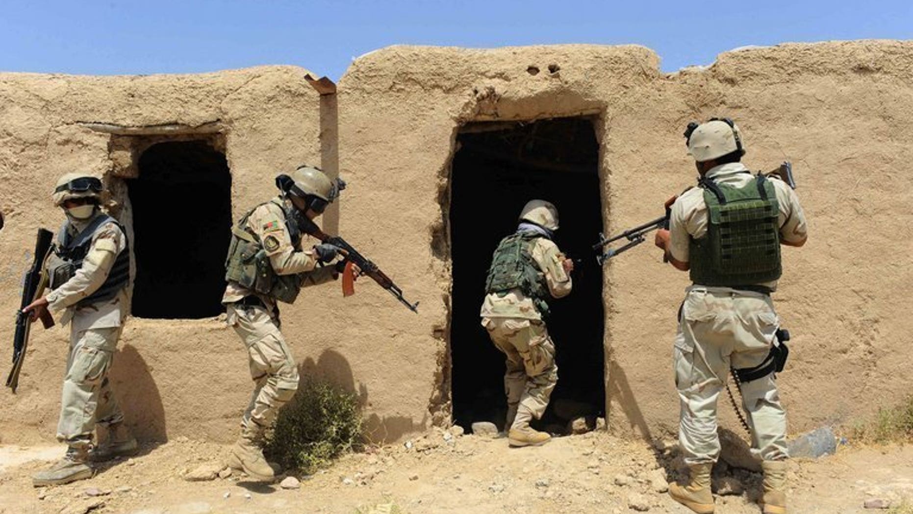 Afghan security forces search a building following an insurgent attack on a road construction workers' camp in Karukh district of Herat on August 17, 2013.