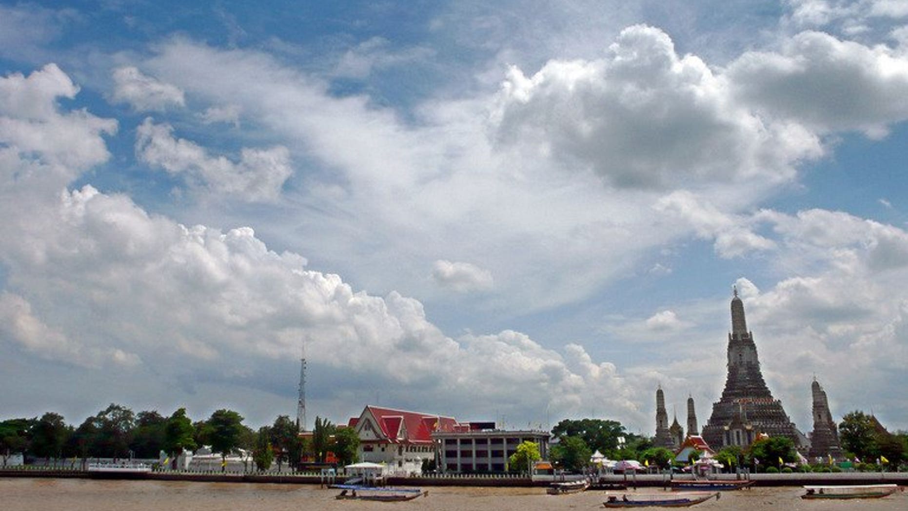 Thai motor boats sail on the Chao Phraya river along Wat Arun Buddhist temple in Bangkok, July 7, 2007.