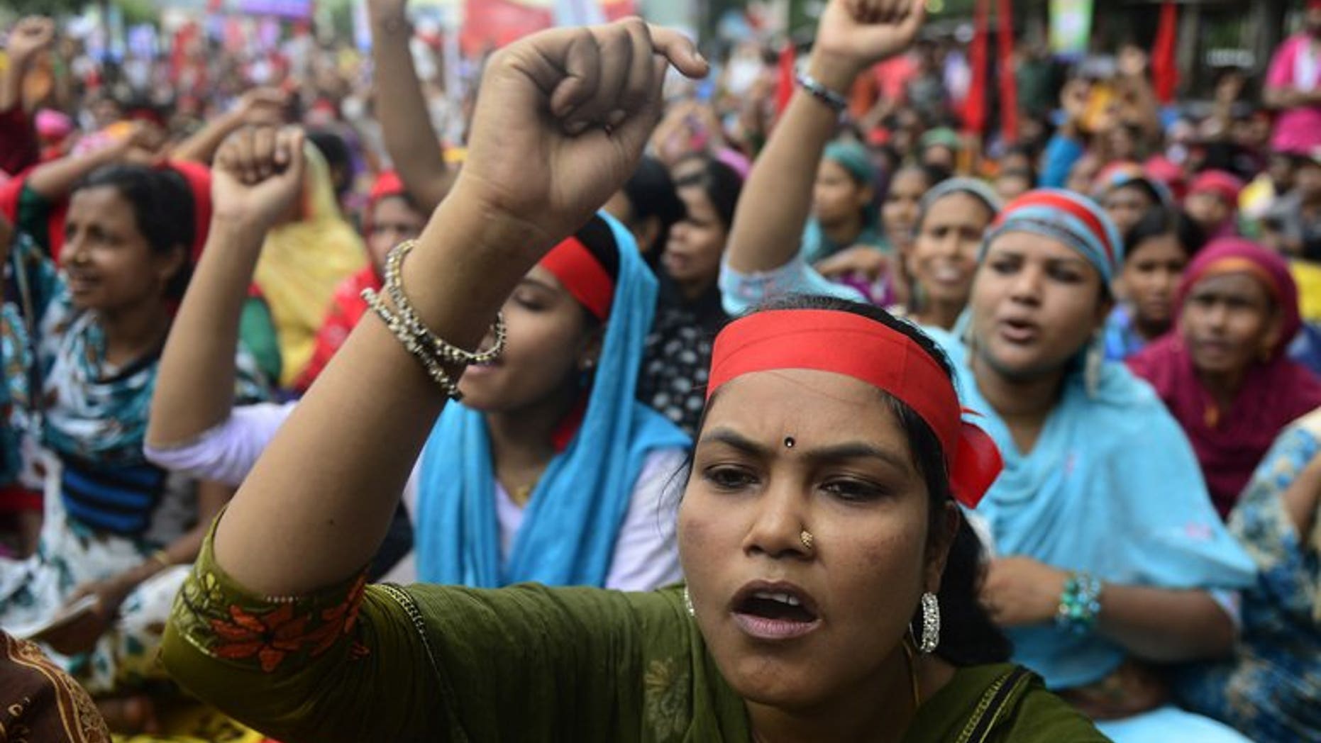 Bangladeshi garment workers shout slogans as they demand a wage increase during a rally in Dhaka, on September 13, 2013. Thousands of Bangladesh garment workers blocked roads and attacked factories outside the capital Dhaka, demanding a $100 minimum monthly wage.
