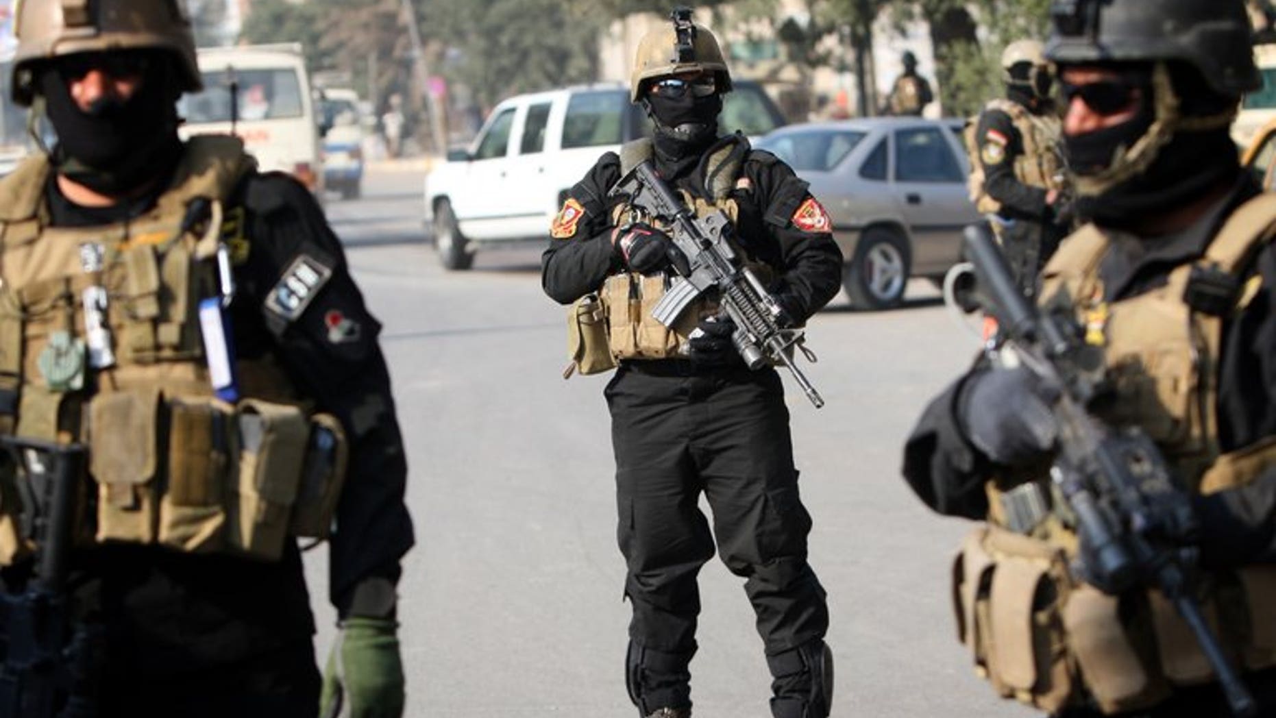 Iraqi anti-terror police stand guard at a checkpoint in Baghdad, on January 6, 2011. At least four police officers have been killed after suicide bombers attacked their base in Baiji, according to a fellow officer and a doctor.