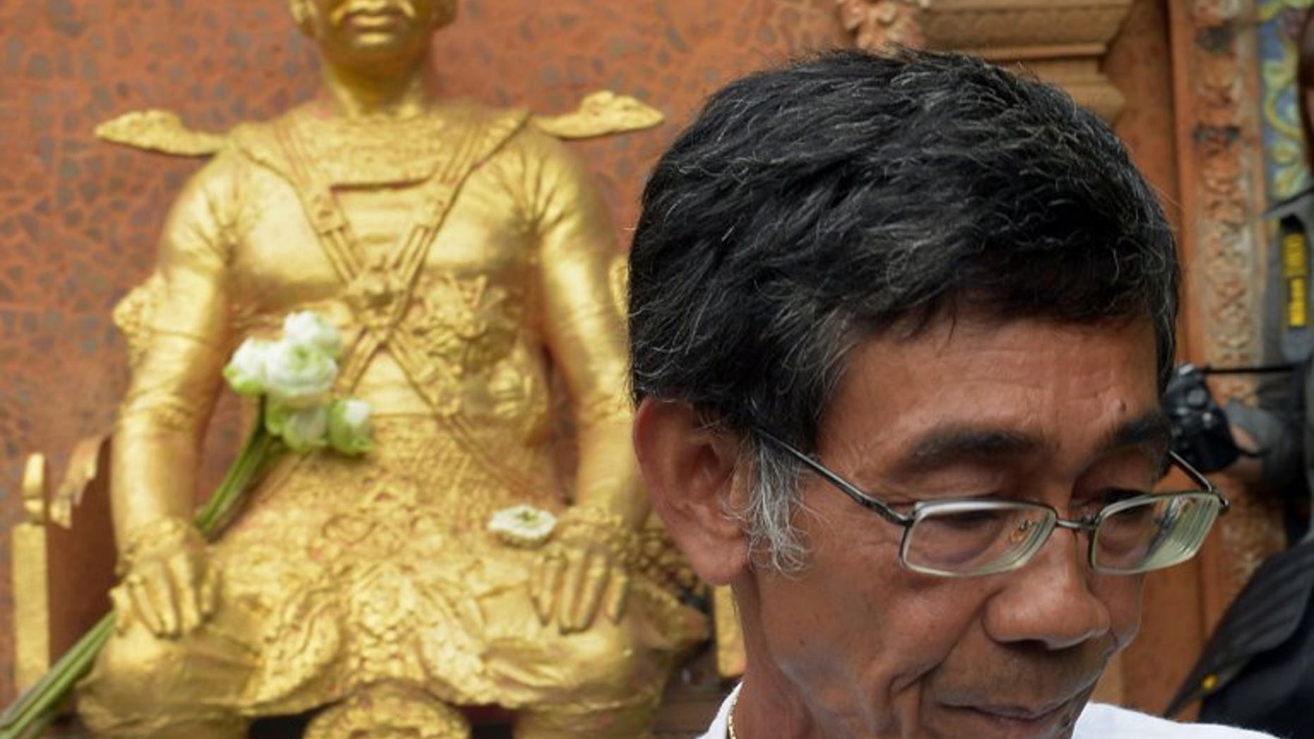Cambodian Prince Sisowath Thomico walks past a statue of King Sisowath after praying and laying flowers during his hunger strike at Wat Phnom in Phnom Penh, on September 20, 2013. The prince has ended a hunger strike over disputed polls after military police expelled him from a pagoda where he was holding the protest fearing it would snowball.