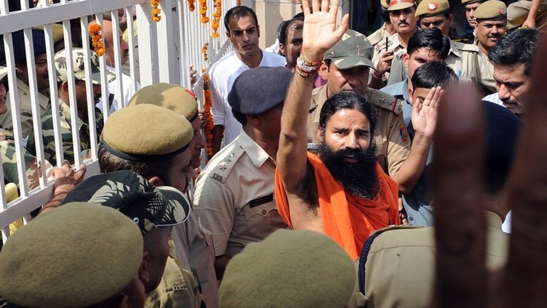 Yoga guru Swami Baba Ramdev (centre) waves to supporters of Indian social activist Anna Hazare as he comes out of Tihar prison during a protest in New Delhi on August 17, 2011. Swami Ramdev, who heads a global yoga empire, was detained Saturday at London's Heathrow airport and questioned for six hours by British customs officials, the Press Trust of India reported.