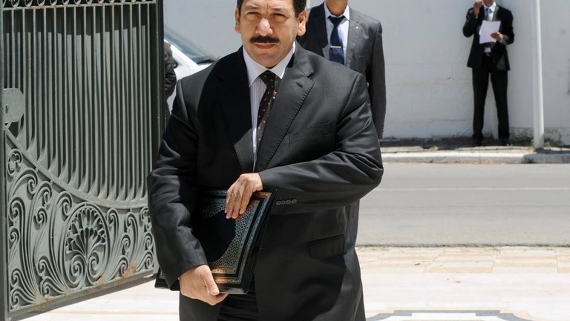 Tunisian Interior Minister Lotfi Ben Jeddou (C) arrives at the Prime Minister's office in Cathage on August 3, 2013.