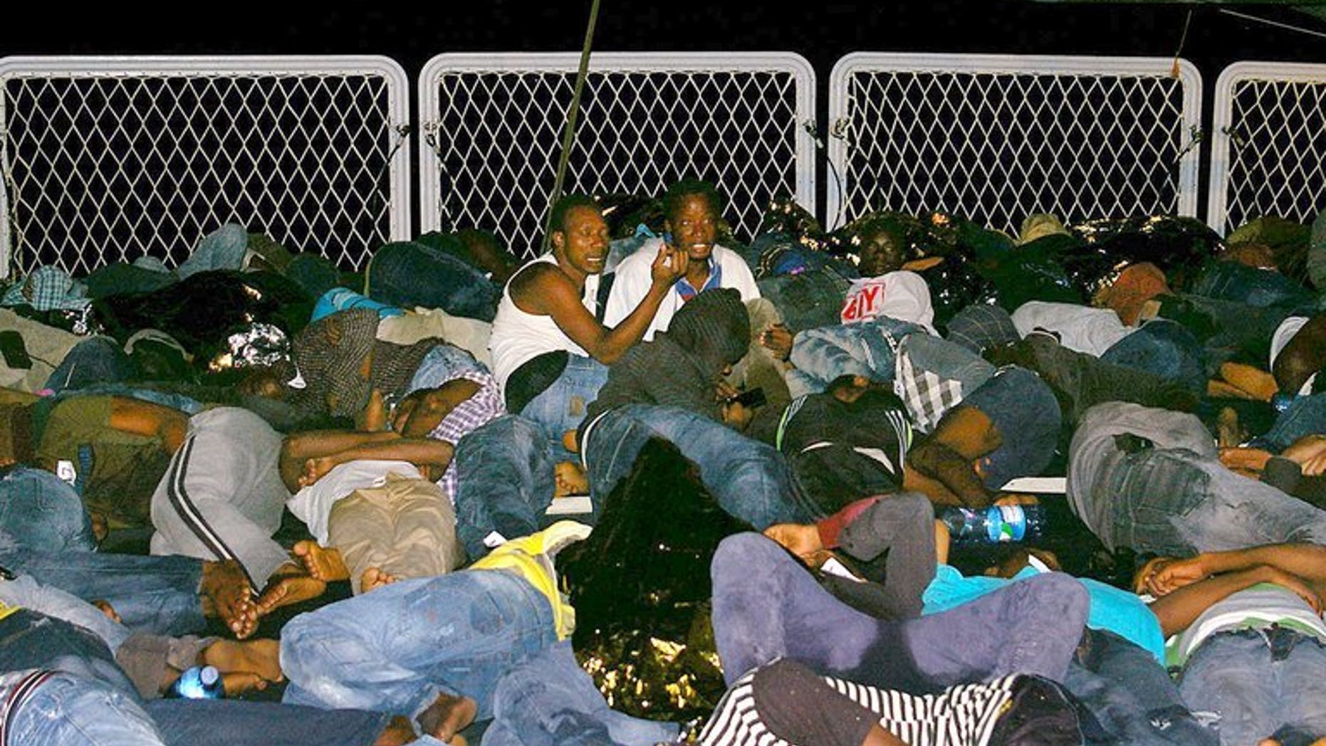 Mainly Syrian refugees rest aboard a boat after being rescued overnight by the Italian Navy near the Italian port of Pozzallo, south of Sicily on September 16, 2013.