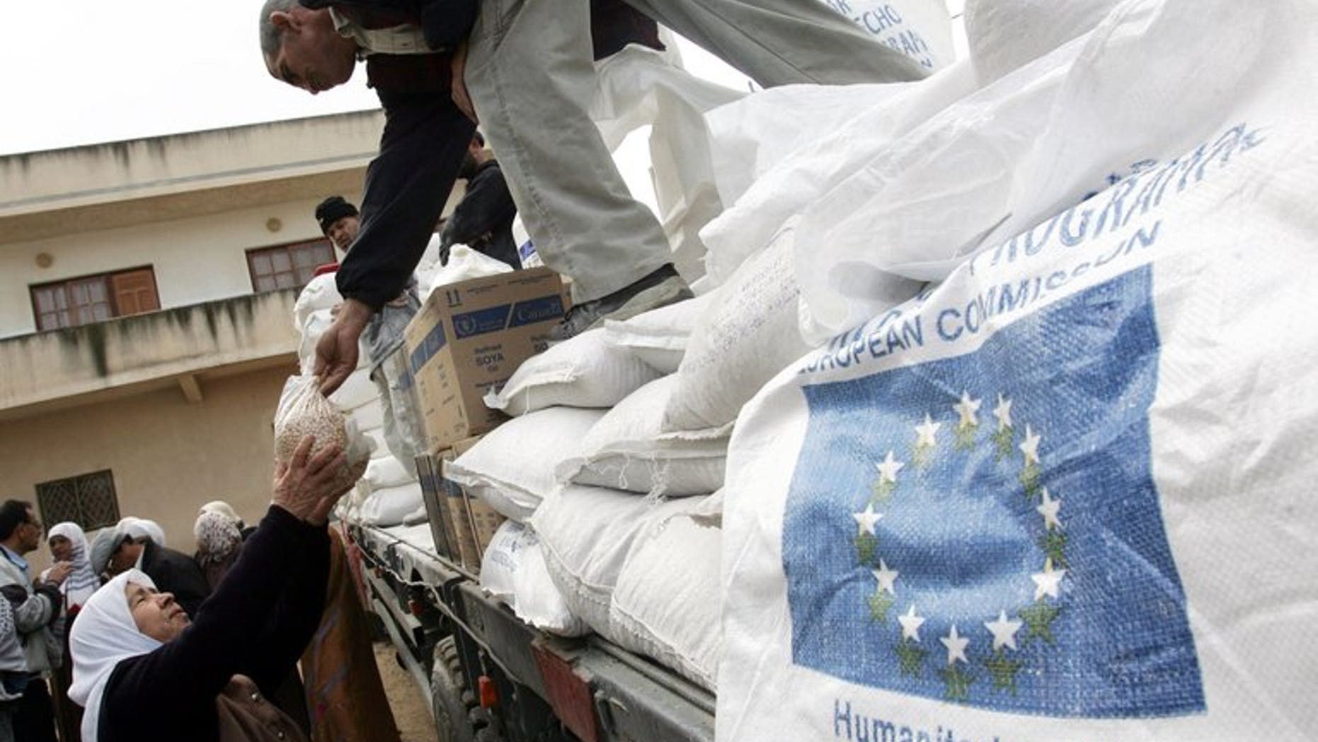 A Palestinian woman receives foodstuffs donated by the European Union through the World Food Programme and distributed by the United Nations Relief and Works Agency (UNRWA) in the West Bank city of Jenin, December 16, 2007.