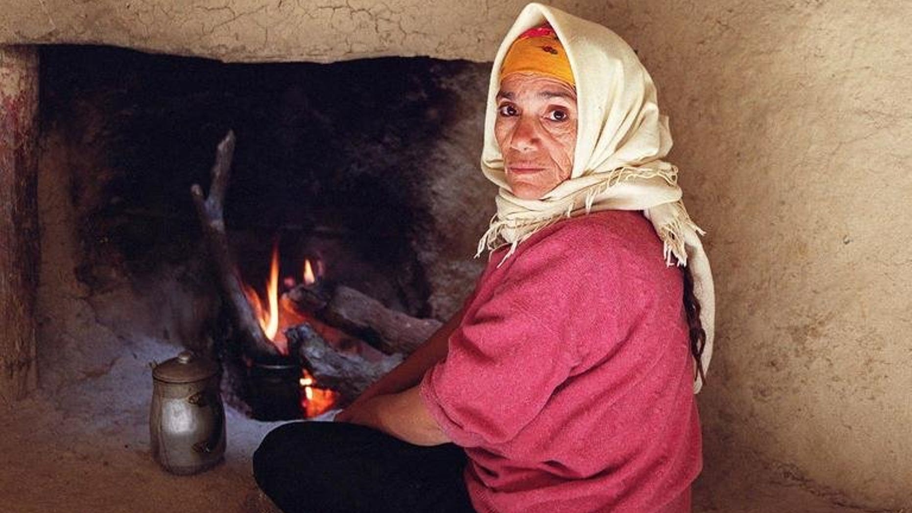 A woman who has never known gas or electricity warms herself 19 February 2001 by a fire in a makeshift home in Cherrata, 100 kms south of Algiers. General Electric Co. has won a $2.2 billion contract to provide turbines for six power plants in Algeria, state energy giant Sonatrach announced on Sunday.