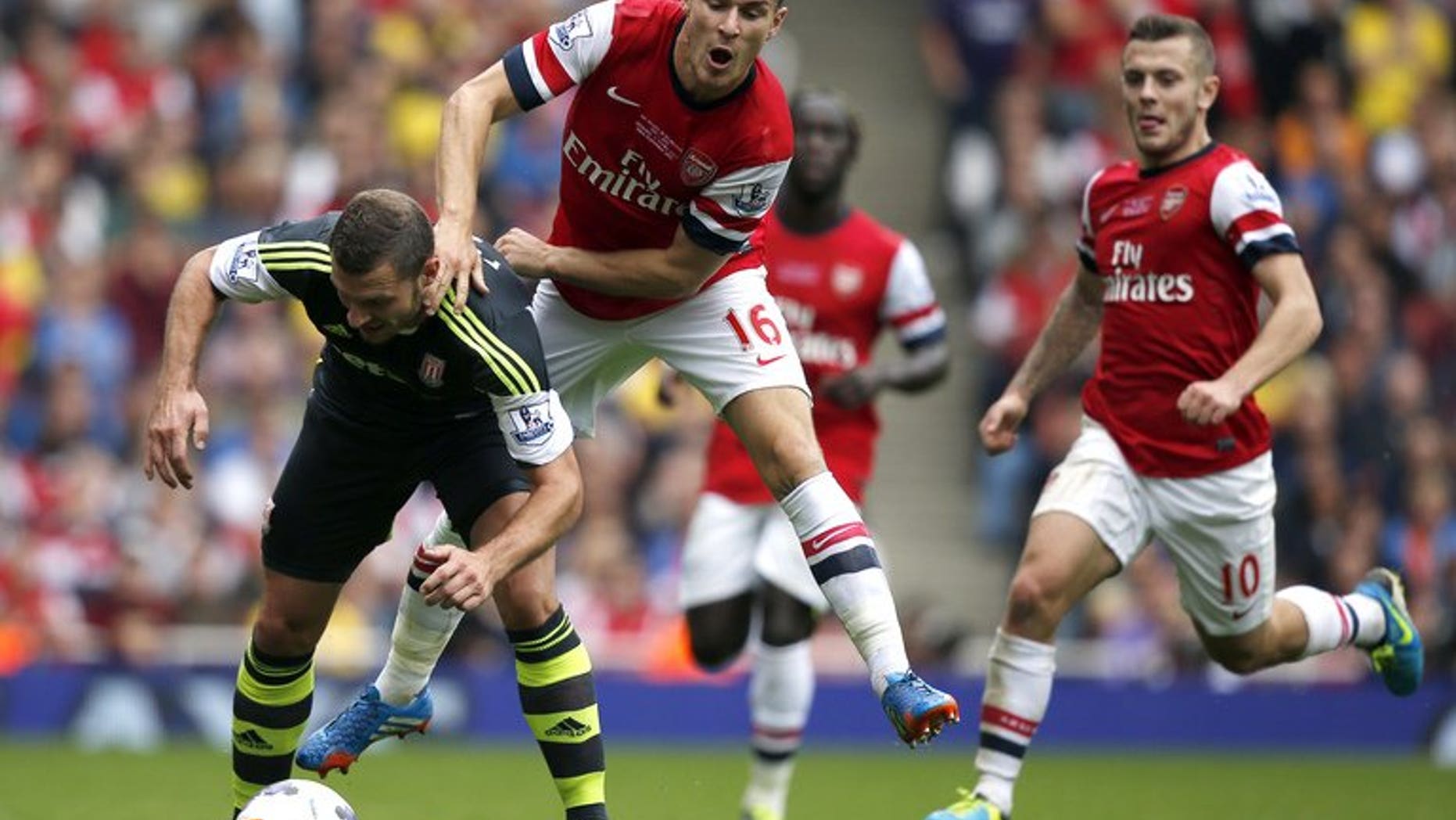 Arsenal's Aaron Ramsey (second left) and Stoke City's Erik Pieters at the Emirates Stadium, London on September 22, 2013. Arsenal went to the top of the English Premier League table after a 3-1 victory at home to Stoke on Sunday.
