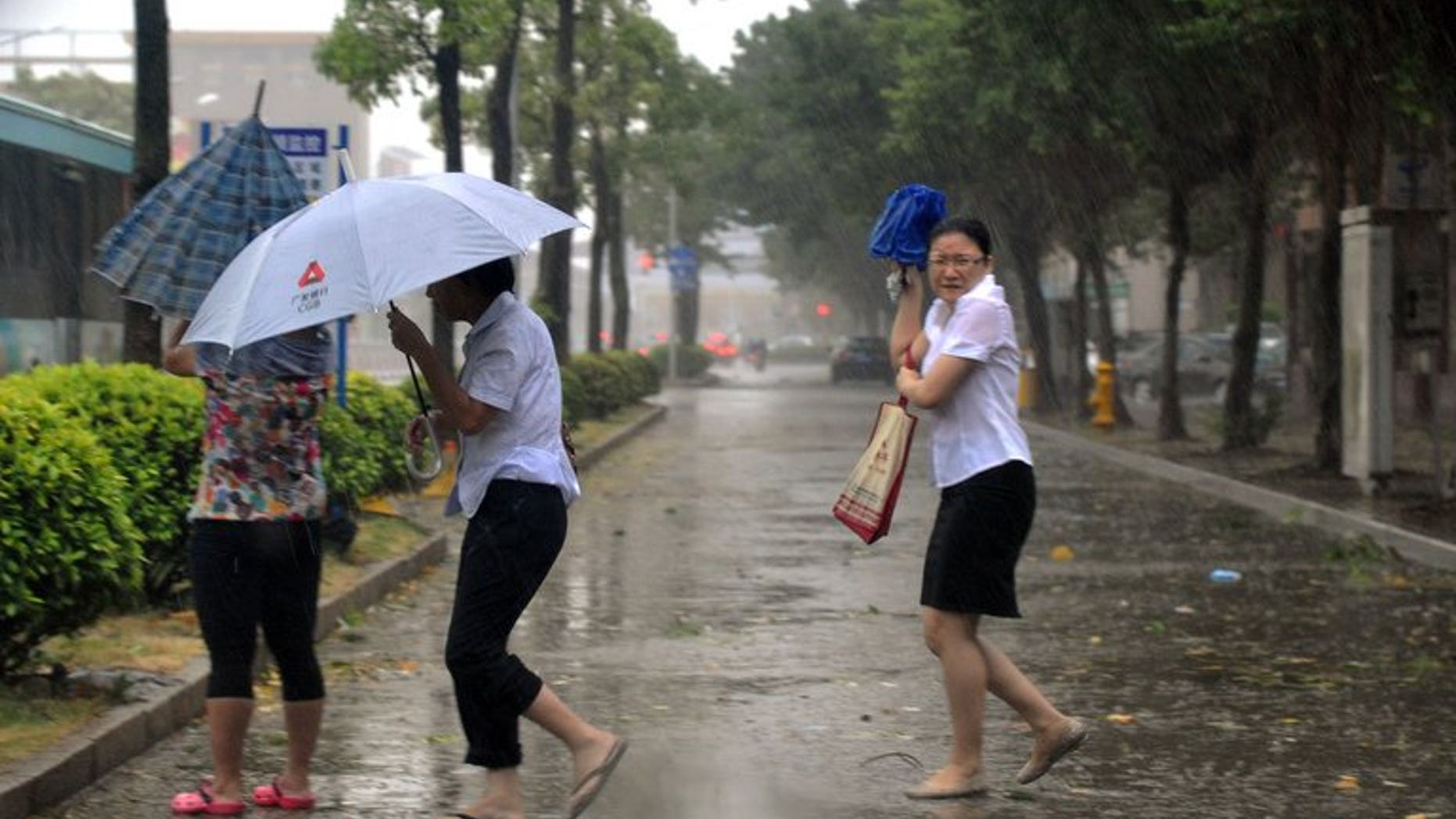 People take cover in Shantou, southern China, on September 22, 2013. Typhoon Usagi has left 25 people dead in southern China's Guangdong province, state media reported.