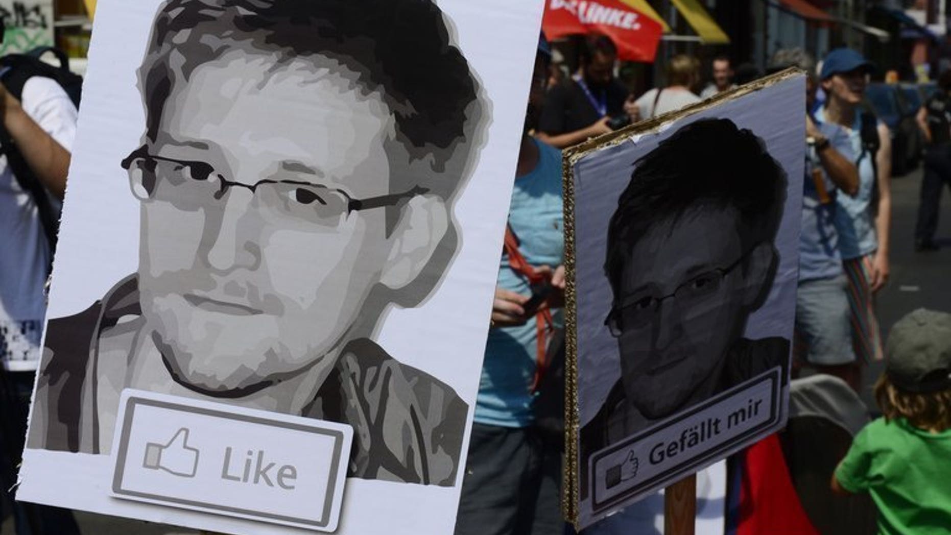 Protesters hold placards bearing the image of former NSA contractor Edward Snowden, in Berlin on July 27, 2013.