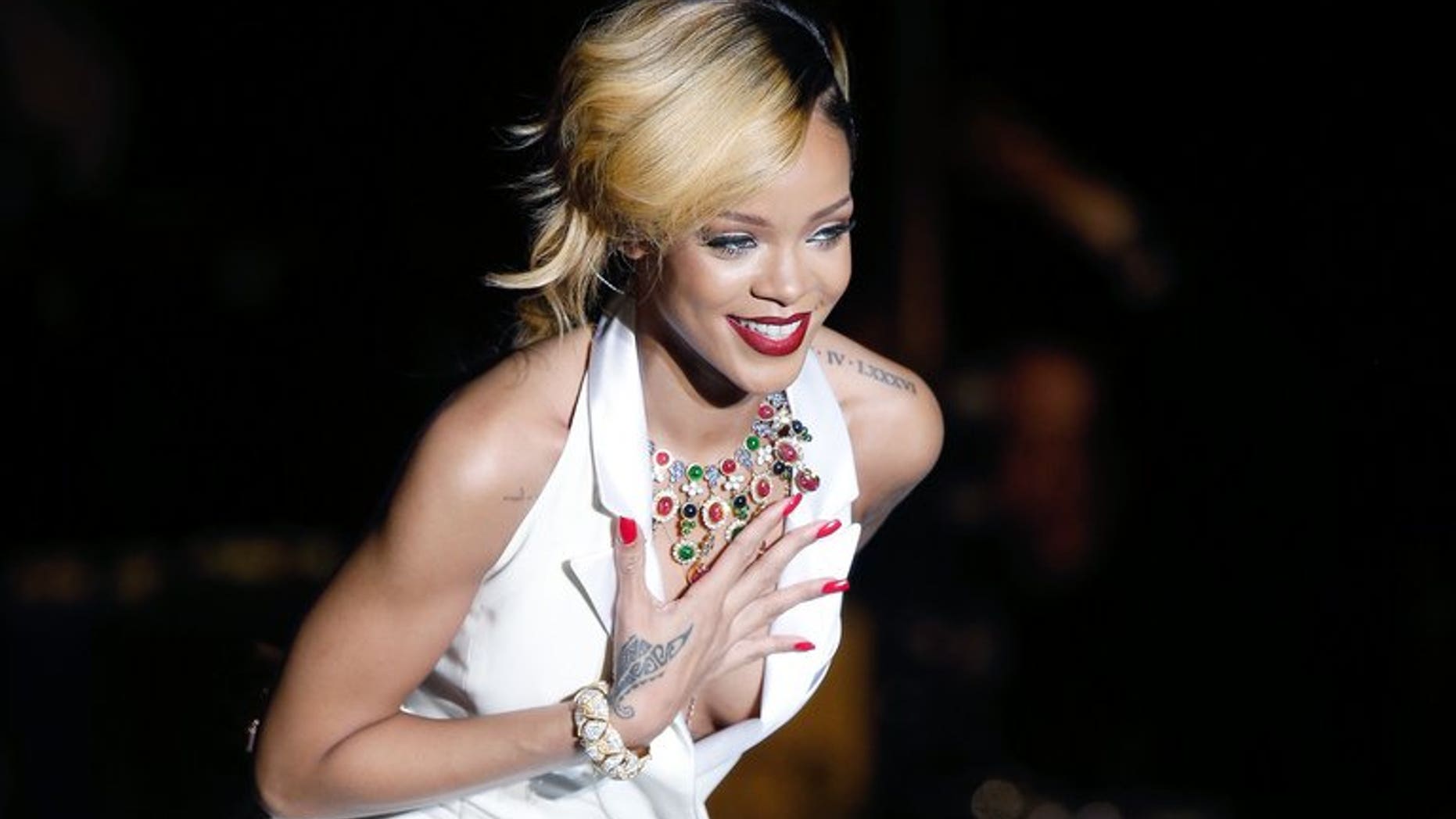Barbadian singer Rihanna performs on stage in Monaco, on July 10, 2013. Thai authorities say two men have been arrested on suspicion of possessing a protected primate after Rihanna posted a picture of herself online holding the creature.