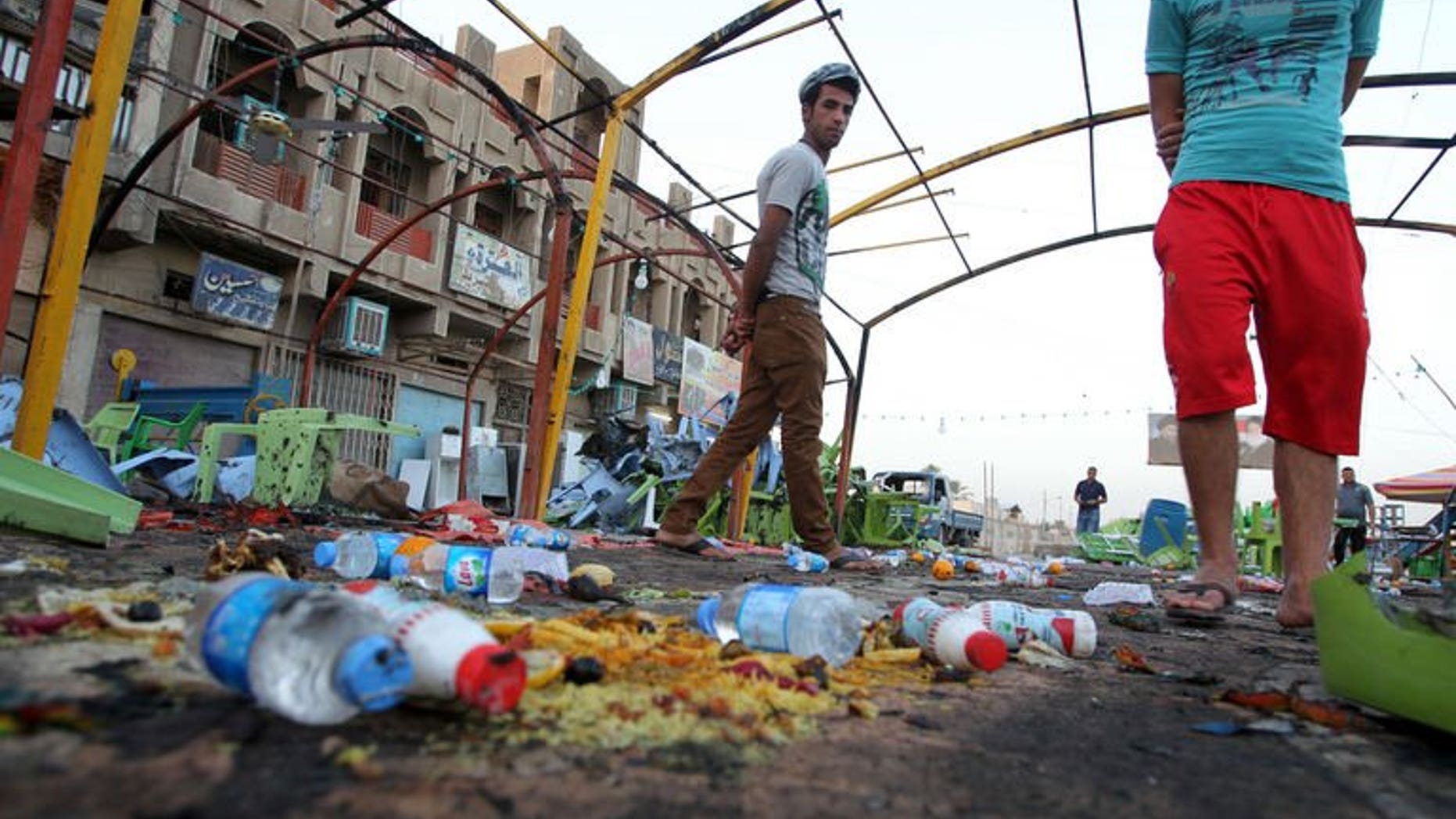 Iraqis inspect the site the day of a bombing attack near a funeral tent in the Sadr City district of Baghdad on September 22, 2103.