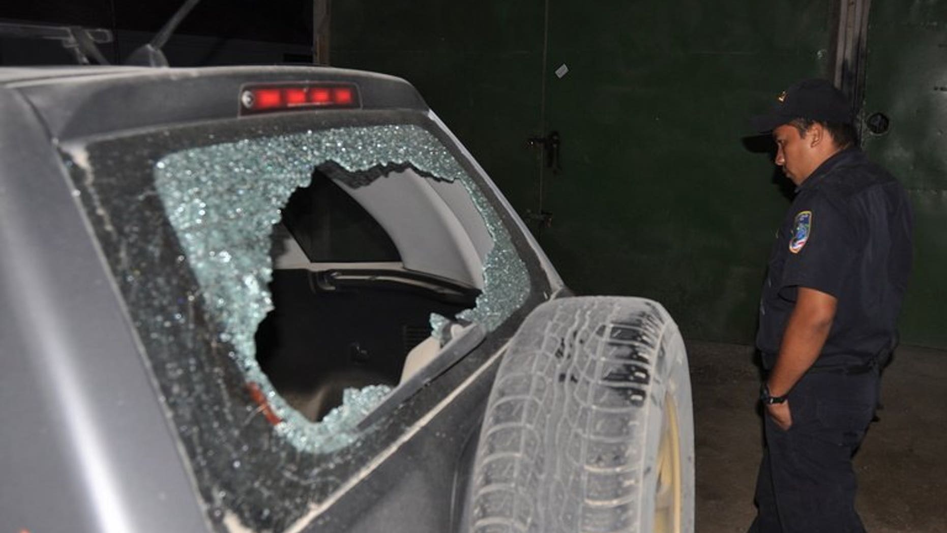 A Costa Rican police officer inspects the damage caused by gunfire on the car used by AFP photographer Yuri Cortez and local photographer Carlos Aviles during their coverage of the second wedding of Brazilian supermodel Gisele Bundchen and US football star Tom Brady on April 4, 2009 in Santa Teresa.