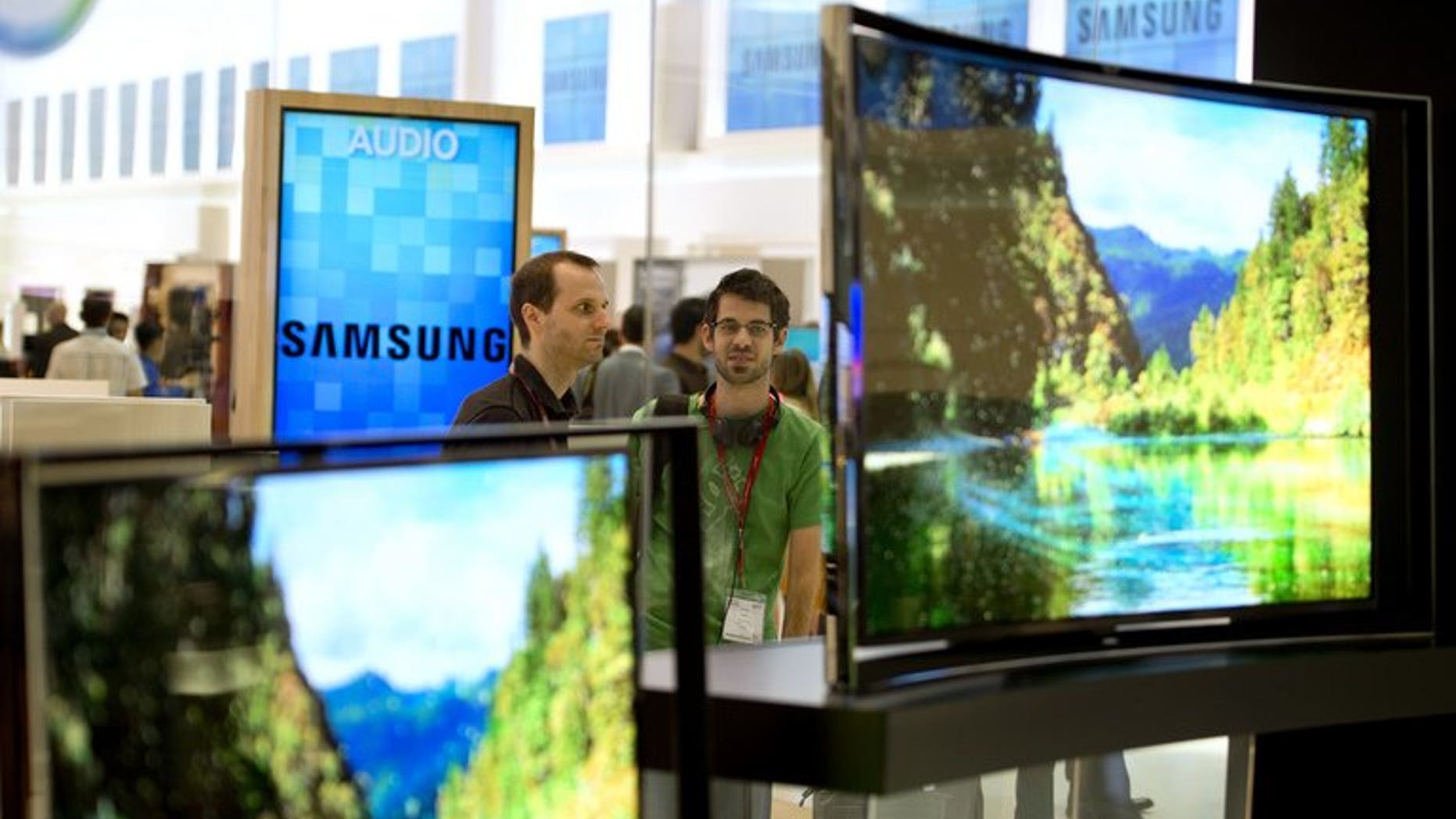 People look at curved OLED TV screens in Berlin on September 5, 2013.
