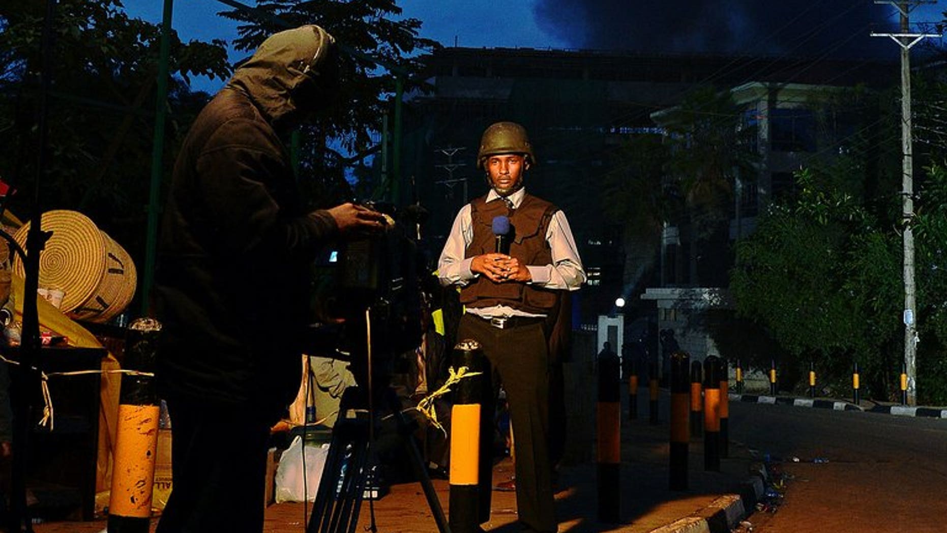 A Kenyan TV presenter stands in front of smoke rising from Westgate Mall on September 23, 2013.There were no leaks or 'chatter' intercepted from Somalia's Shebab Islamist rebels ahead of the attack on Nairobi's Westgate shopping mall, intelligence sources from two foreign countries told AFP Tuesday.