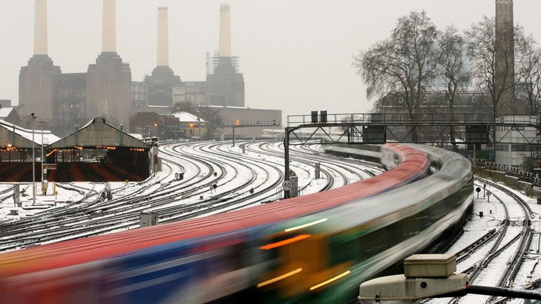 Commuter trains run past Battersea Power Station as snow falls in central London, February 8, 2007. British rail operator National Express announced Tuesday it has won a 1.6-billion-euro ($2.2-billion) contract to operate two regional services in Germany's most populous state, North Rhine-Westphalia.
