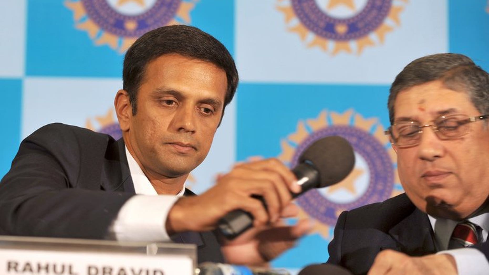 Indian cricketer Rahul Dravid (left) hands a microphone to Board of Control for Cricket in India President Narayanaswami Srinivasan at a press conference in Bangalore on March 9, 2012. India's powerful cricket chief Srinivasan faces a last-minute legal challenge to his attempted return to the top job following a betting scandal that has rocked the sport, a lawyer said Tuesday.