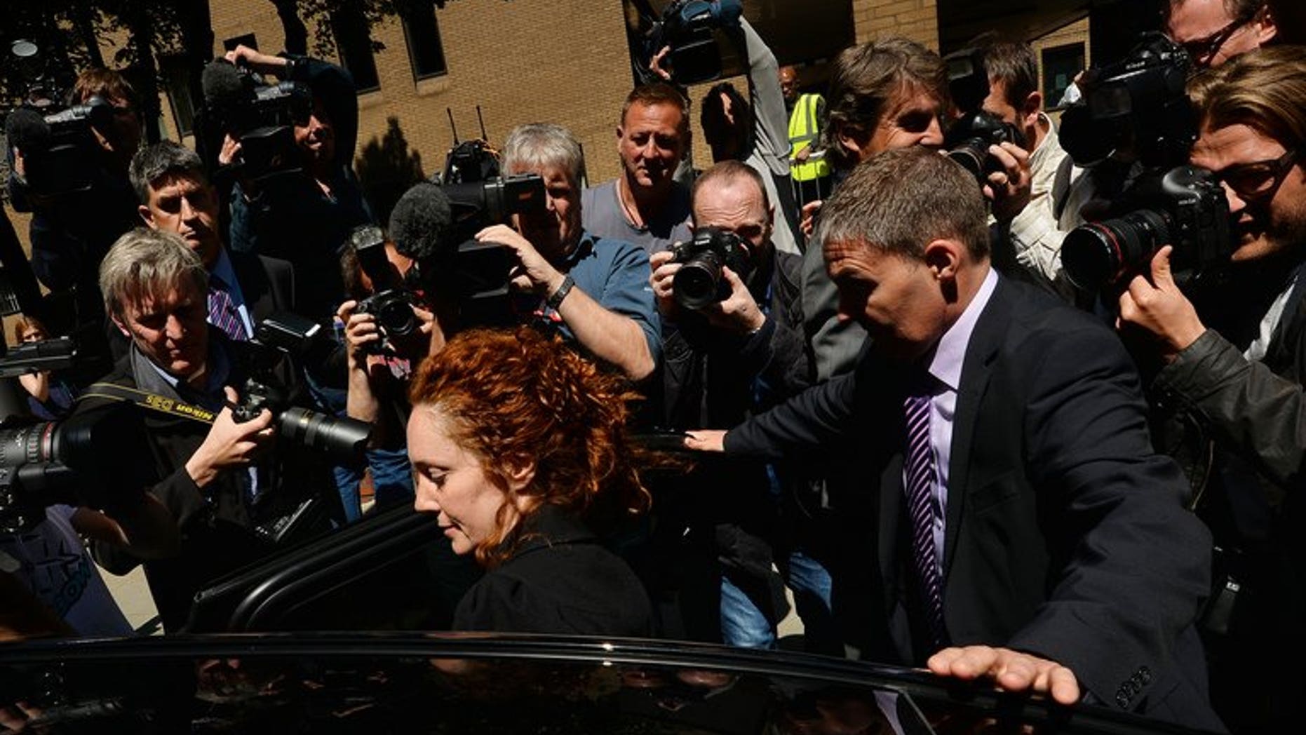 Members of the media surround former News International chief executive Rebekah Brooks in London on June 5, 2013 after attending a hearing into charges linked to the phone-hacking scandal. A member of staff at London's Metropolitan Police headquarters was one of two people arrested on Tuesday as part of a bribery investigation sparked by the phone-hacking scandal at the News of the World tabloid.