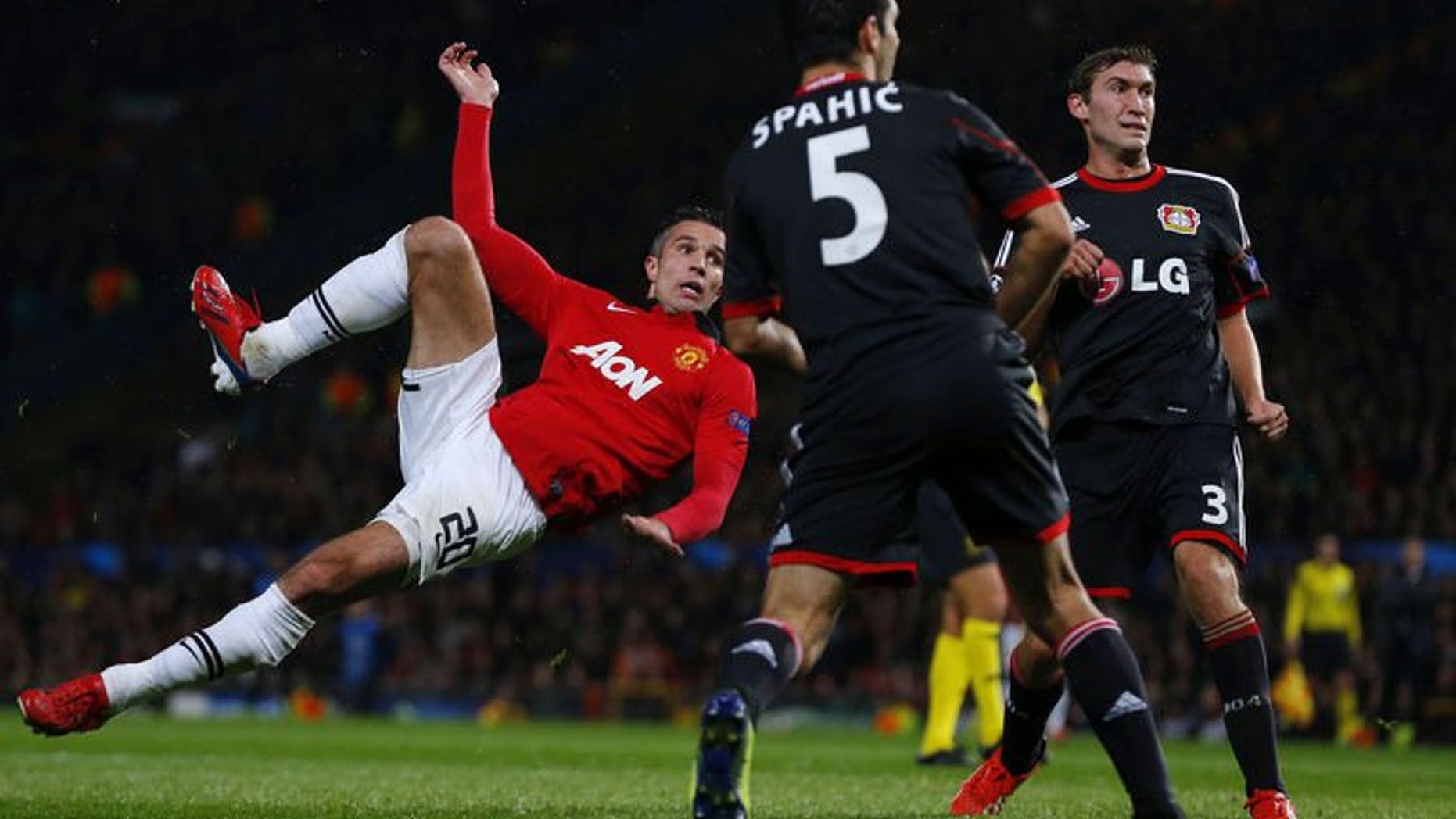 Manchester United striker Robin van Persie (L) scores during the Champions League Group A match against Bayer Leverkusen at Old Trafford in Manchester, north west England on September 17, 2013.